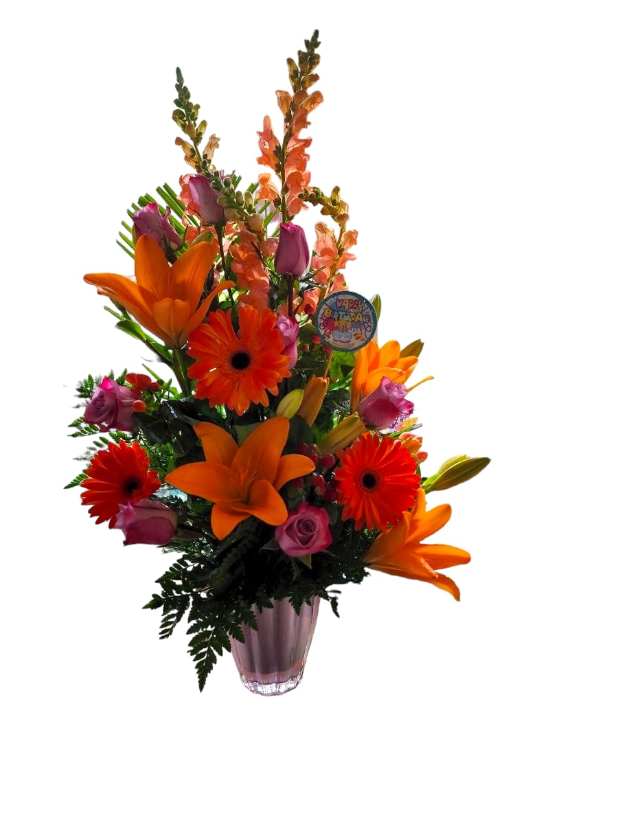 Tropical Blaze - As an expert in the floral industry, we bring you Tropical Blaze - a stunning arrangement of pink vase, orange snapdragon, lilies, gerbera, hot pink roses, hypericon berry, and greenery. With the perfect combination of vibrant colors, this arrangement is sure to brighten any space.