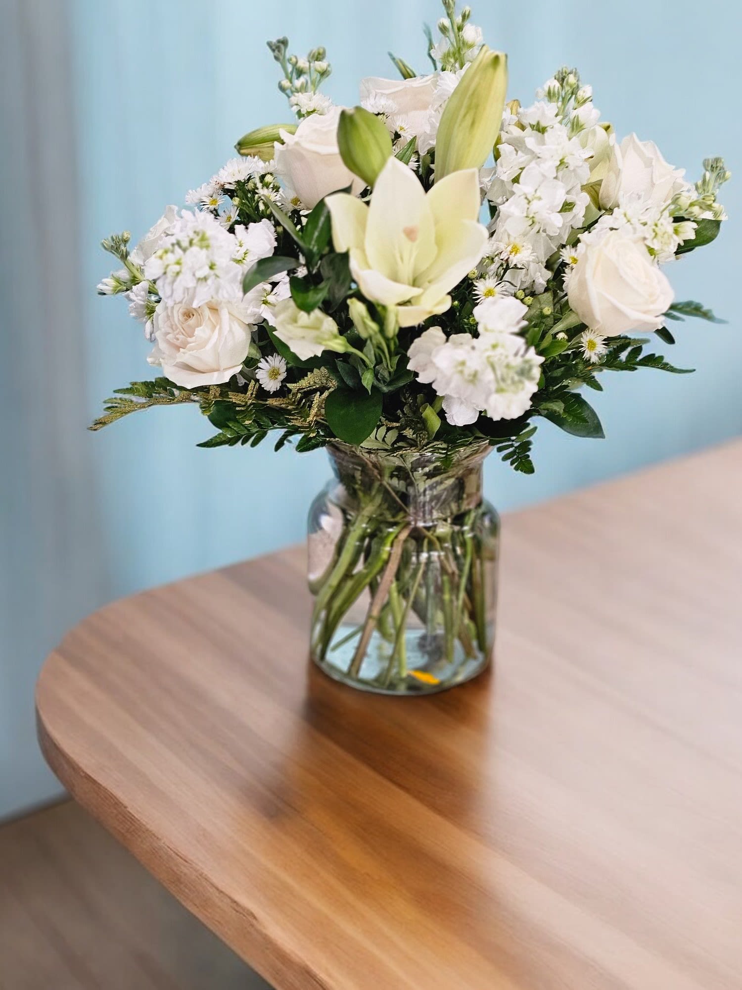 Timeless Elegance - This Arrangement&nbsp; reflect the sophisticated and serene nature of the arrangement, emphasizing the purity and grace of the white blooms and the delicate greenery. The arrangement will be made with Roses, Stock, carnations, Lisianthus, Lilies with filler all on white colors and fine greenery&nbsp;