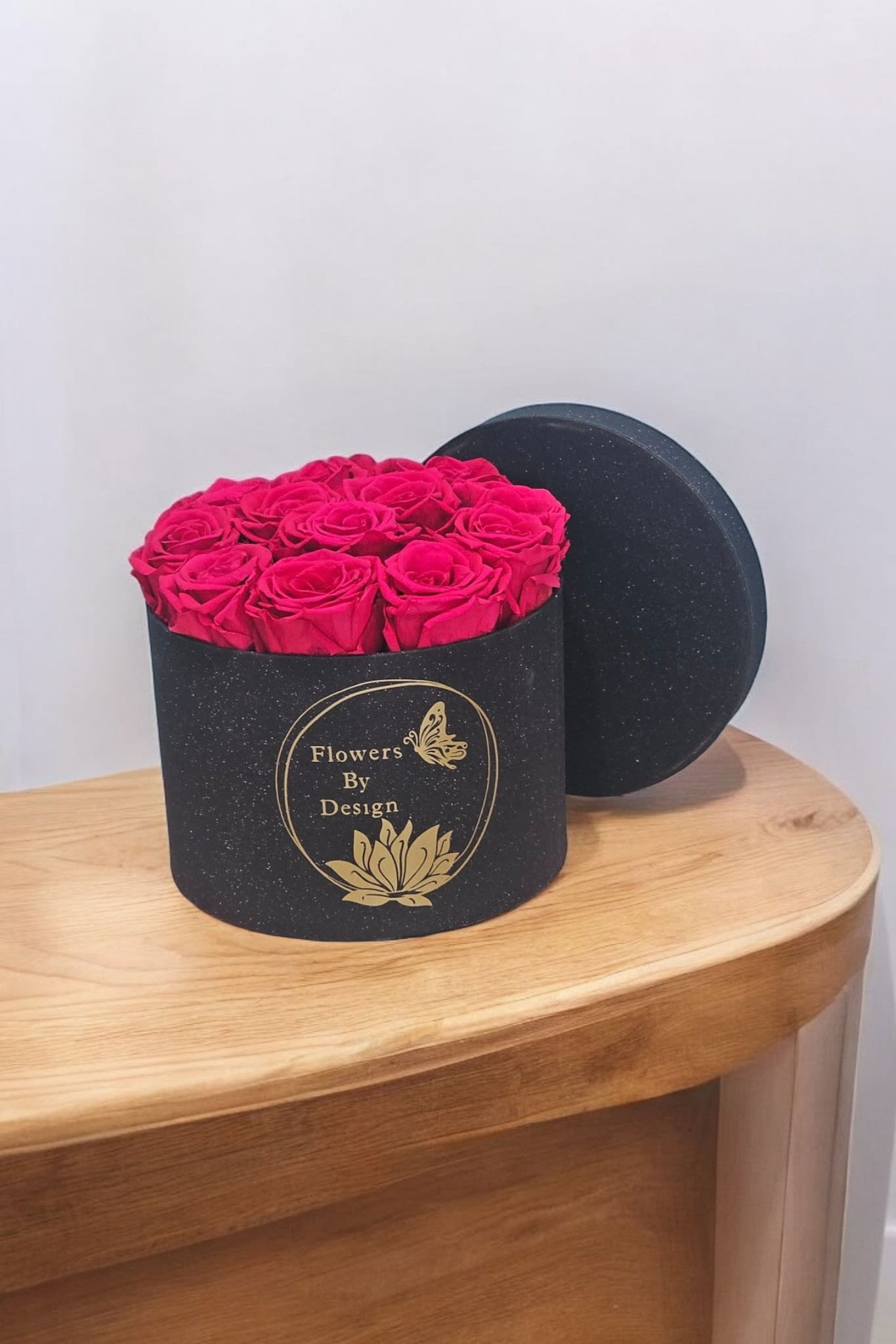 Vivid Noir Elegance - This arrangement highlights the striking contrast of the hot pink roses against the sleek black box, suggesting a touch of sophisticated drama and luxury.