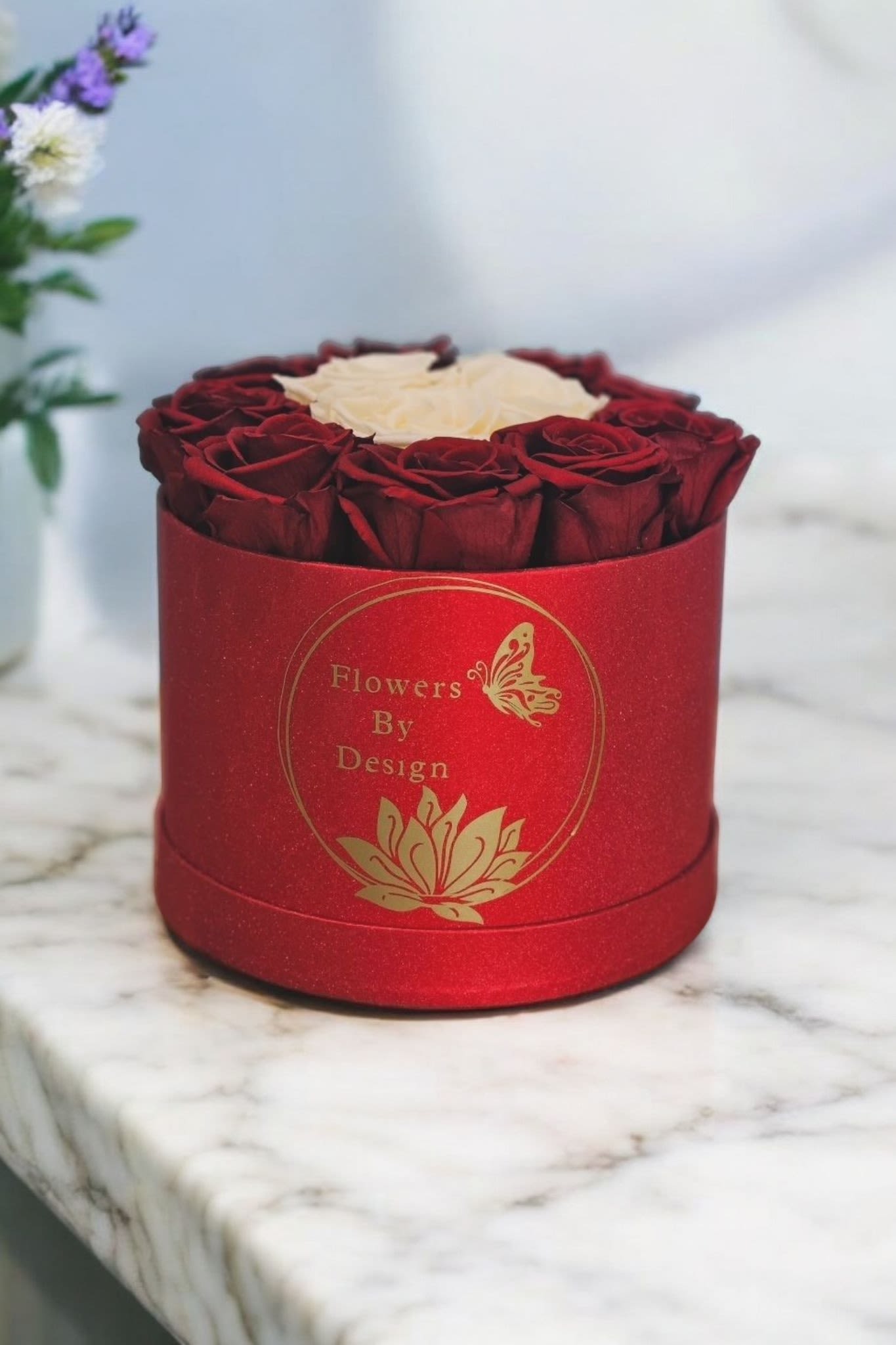 Elegance in Bloom - This arrangment captures the luxurious feel of the red box, the sophistication of preserved roses, and the classic beauty of the white roses in the center. This arrangement is made with Nine red Rose and Three White Rose. if you take good care of them, they can last up to three years.