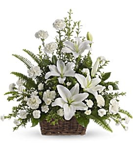 Peaceful White Lilies Basket - This elegant basket includes beautiful white flowers, including carnations, mini carnations, and lilies, accented with an assortment of greenery. Perfect for creating a peaceful and serene atmosphere, these flowers bring a sense of calm to any space.