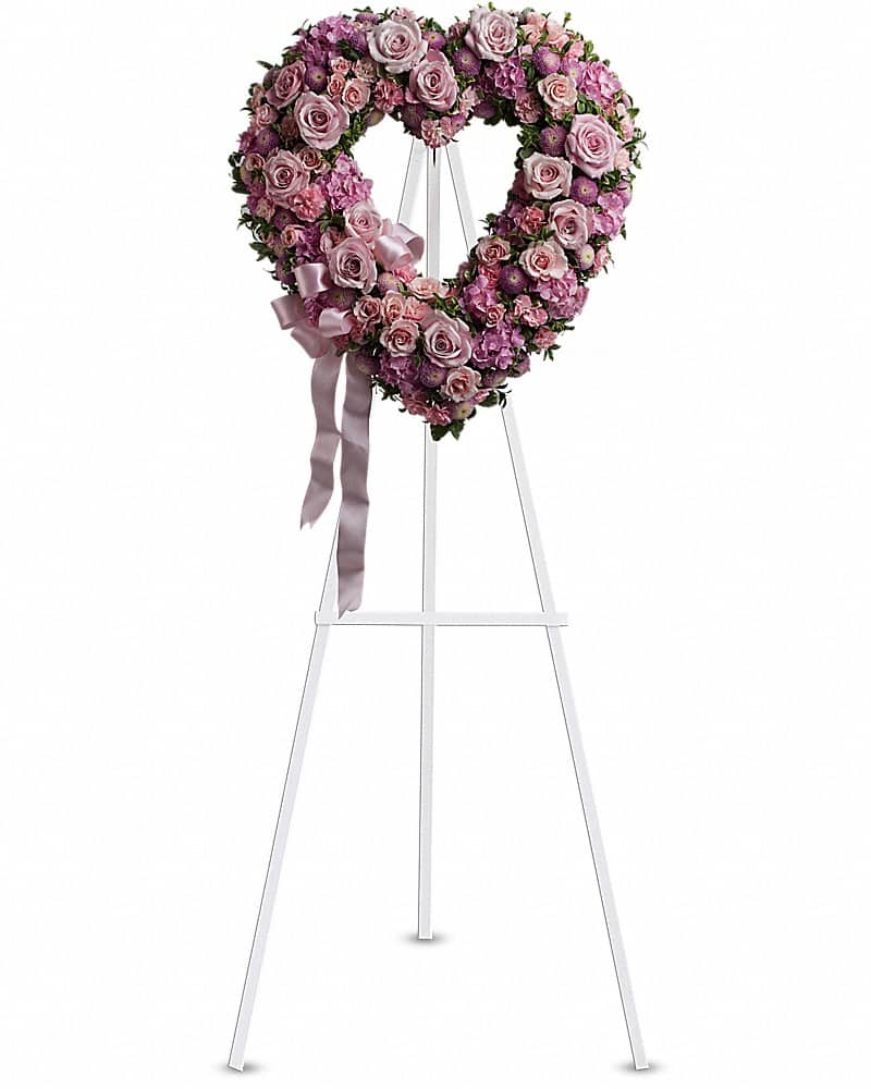 Heart-shaped pink and lavender rose wreath on a white standing easel