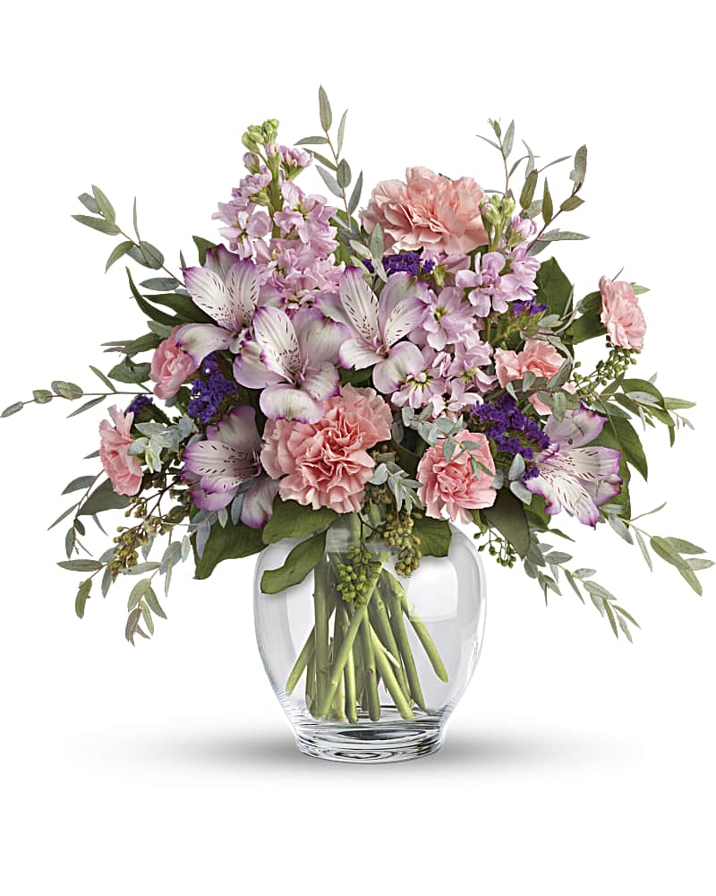 Pastel pink and lavender mixed flower arrangement in a clear round glass vase