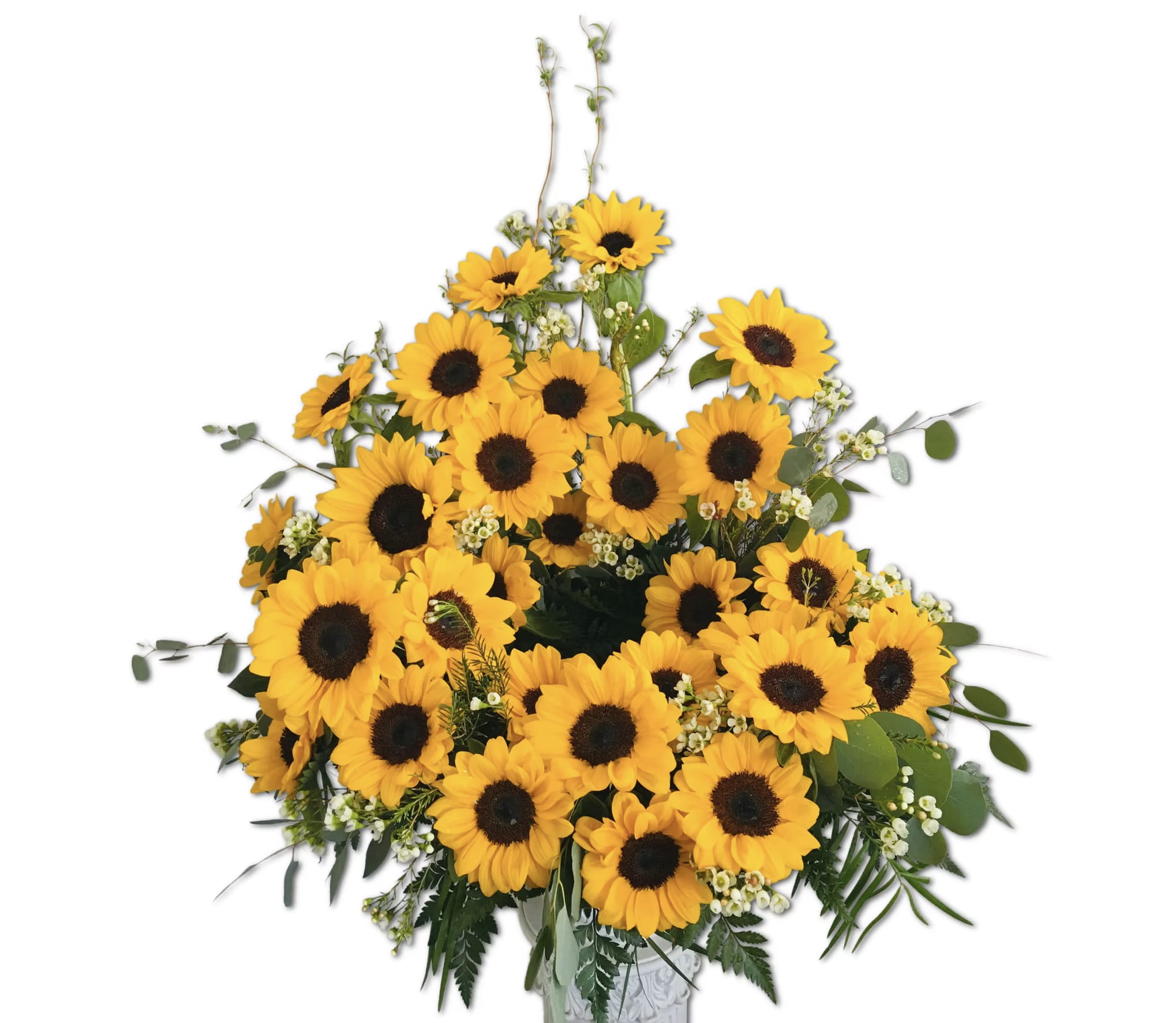 Tall bouquet of bright yellow sunflowers with small white filler flowers in a white vase