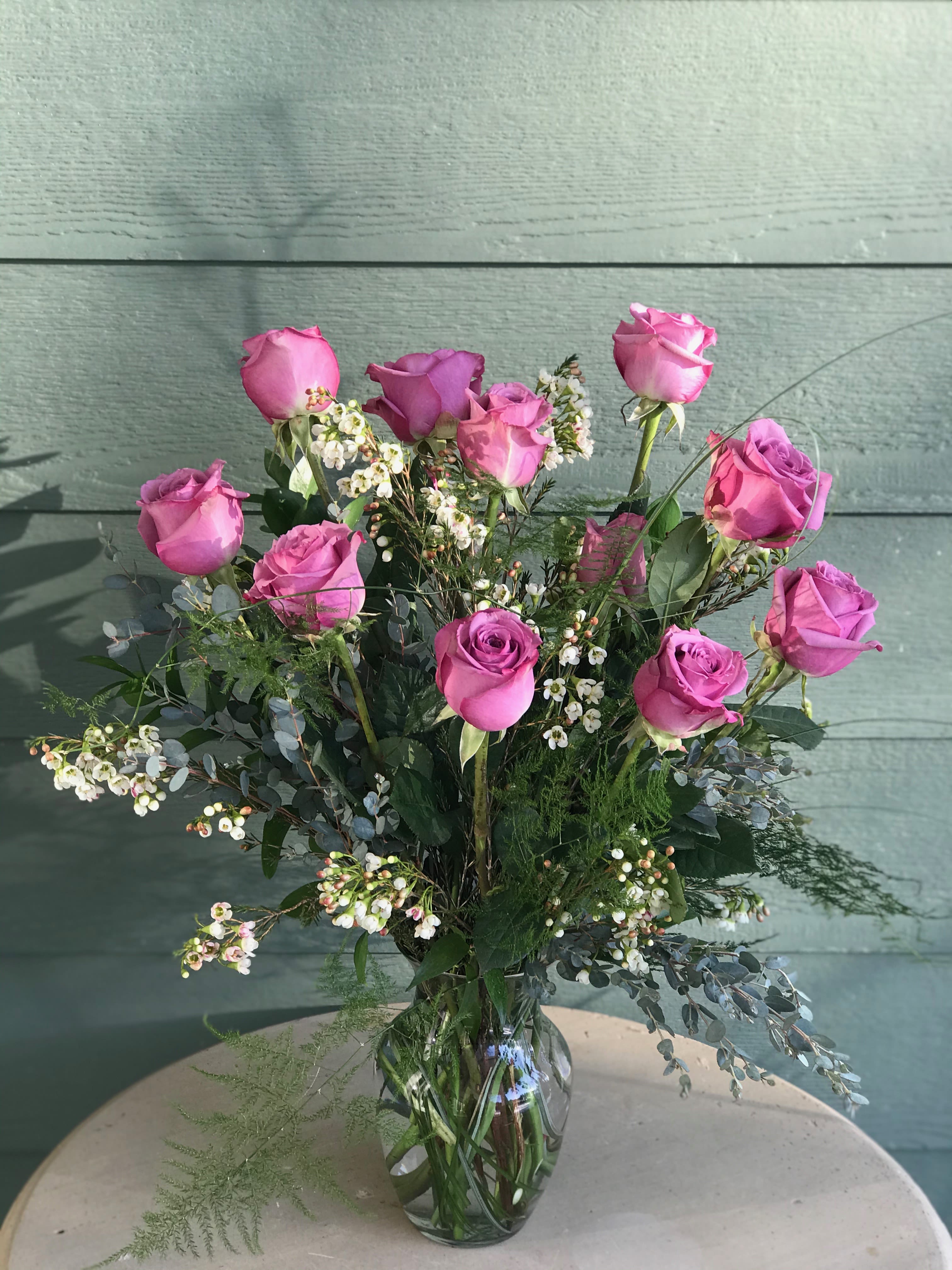 A Dozen Kisses in a Vase  - We will arrange a dozen premium peach, pink or lavender roses with fillers and an array of greenery in a glass vase. Imagine each rose as a kiss from you to your someone special. 