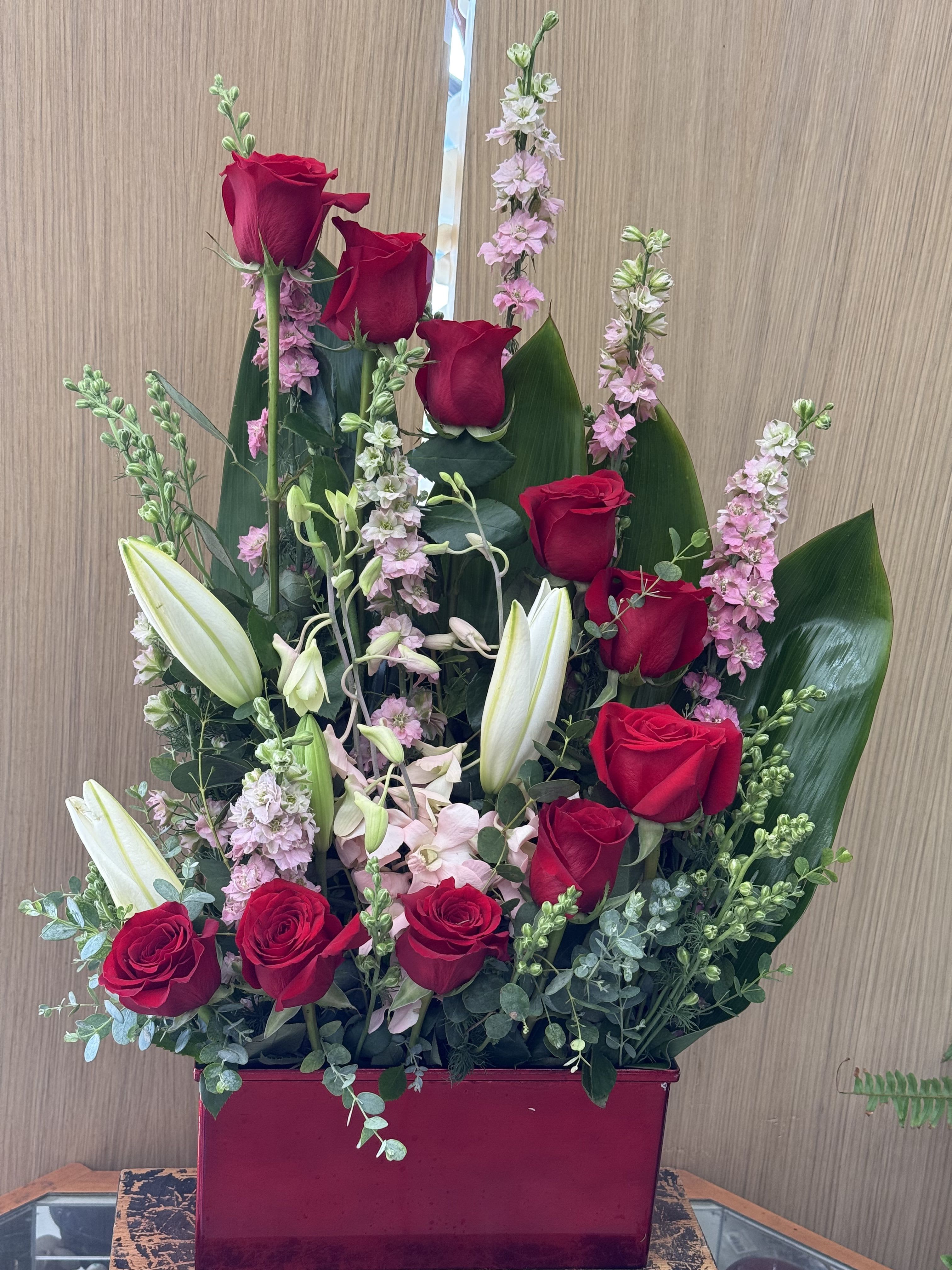 Crescent Rose Arrangement - Roses arranged in a crescent shape with mixed filler and lily’s.