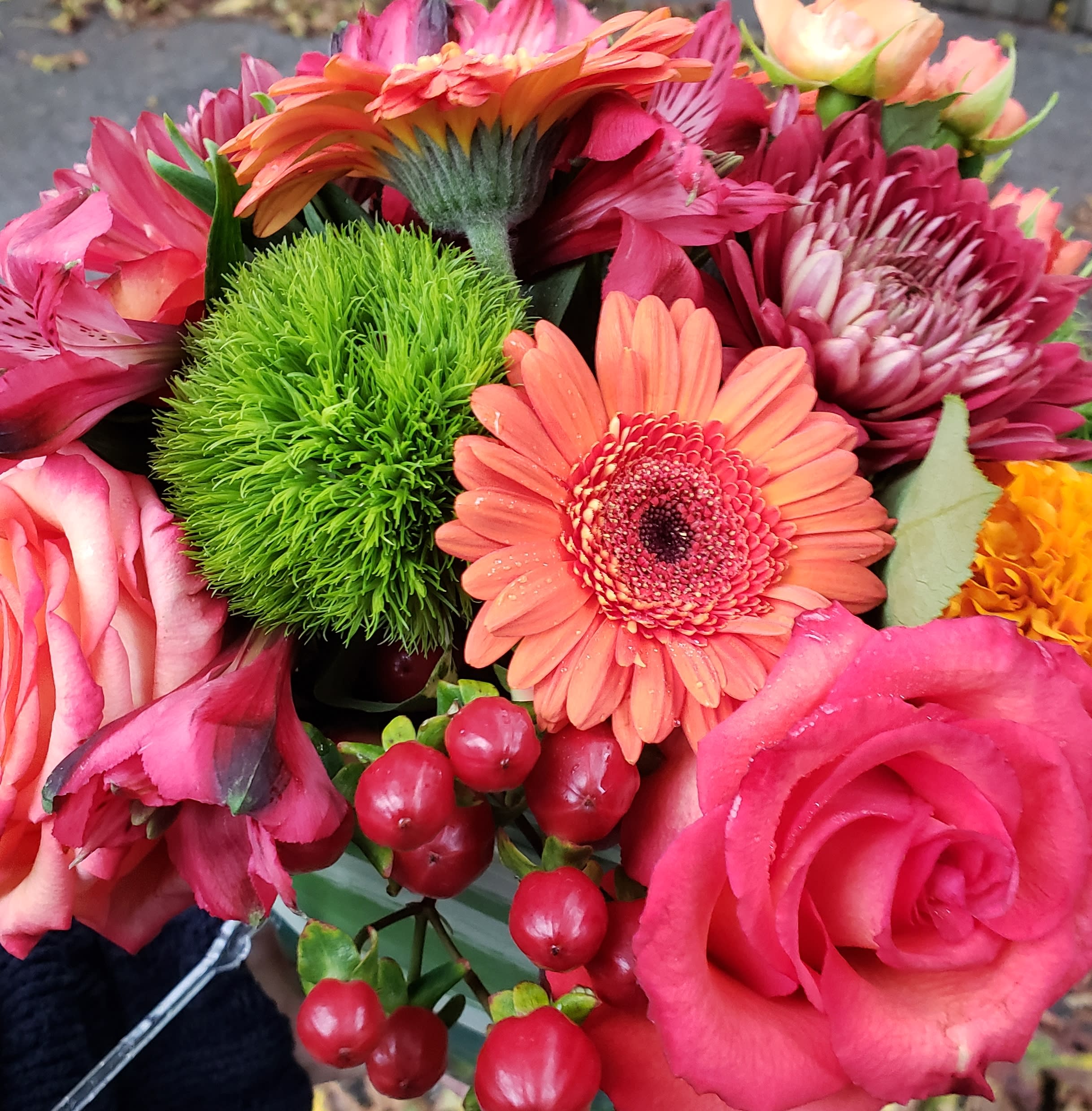 Bright bouquet with pink roses, orange gerbera daisy, green dianthus ball, red berries, and mums