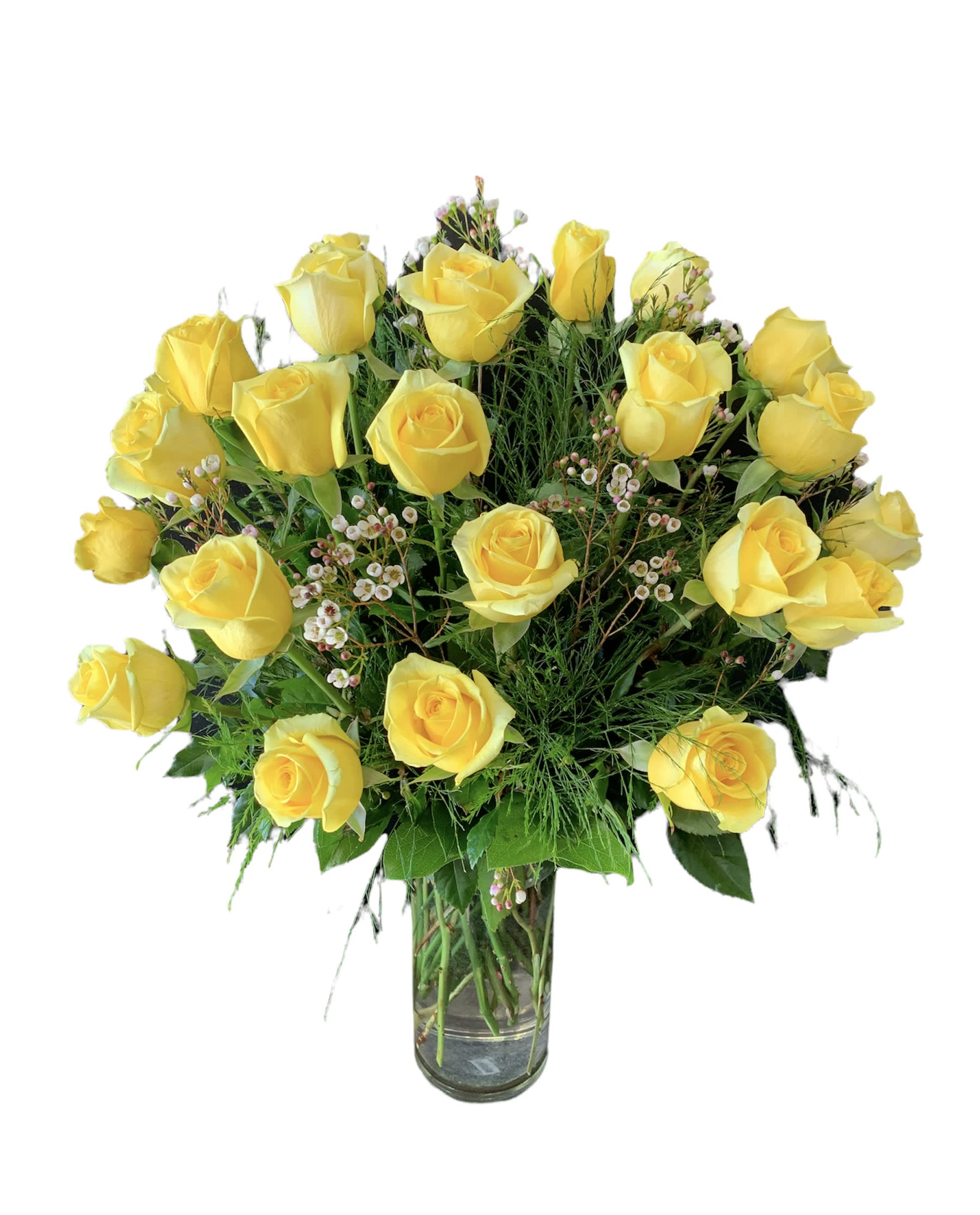 Tall arrangement of yellow roses with small white filler flowers in a clear glass vase