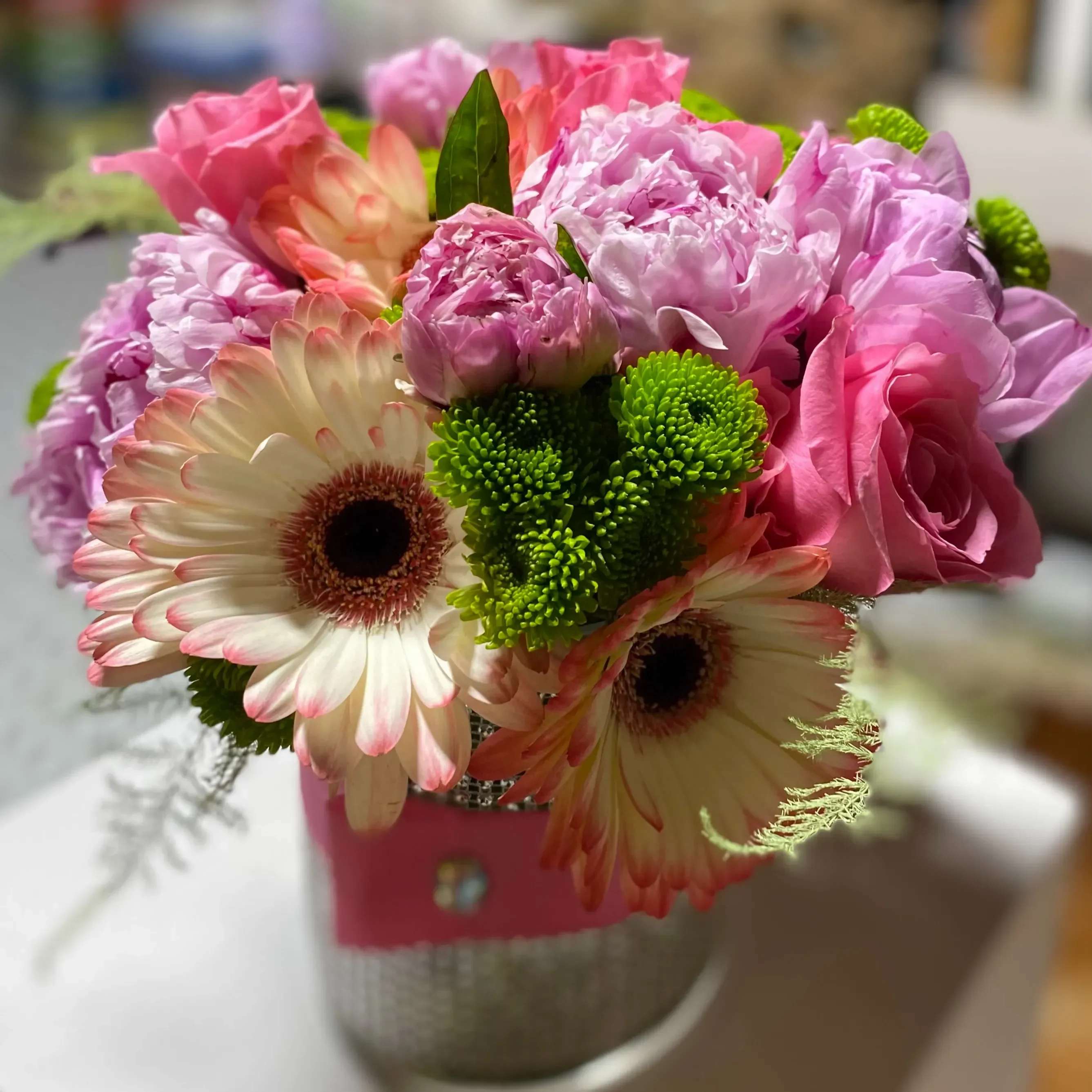 Pink Charmon  - This arrangement contains spray roses, roses, whimsical snapdragons, stock some orchid's and more.  This is a great birthday gift. APPROXIMATE DIMENSIONS: 9"L X 9"W x 9"H for a standard arrangement 