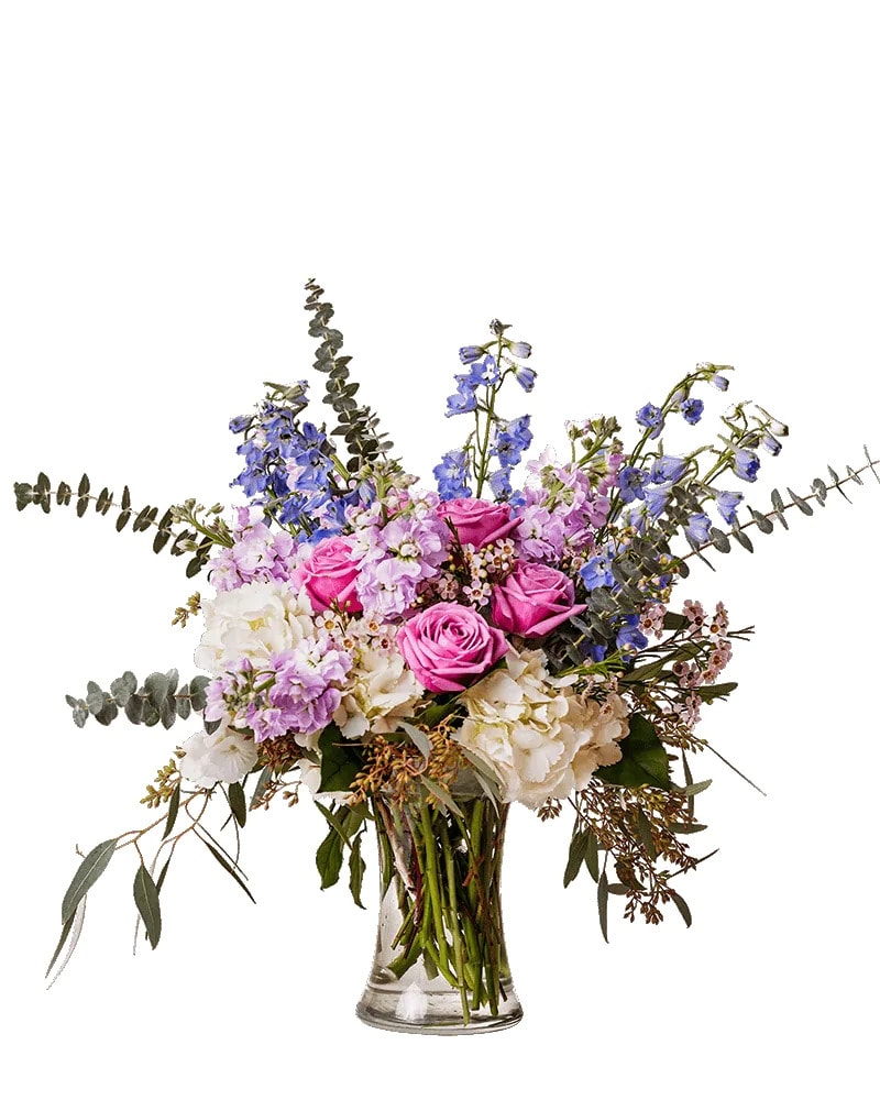 Pink roses and lavender flowers in a clear glass vase