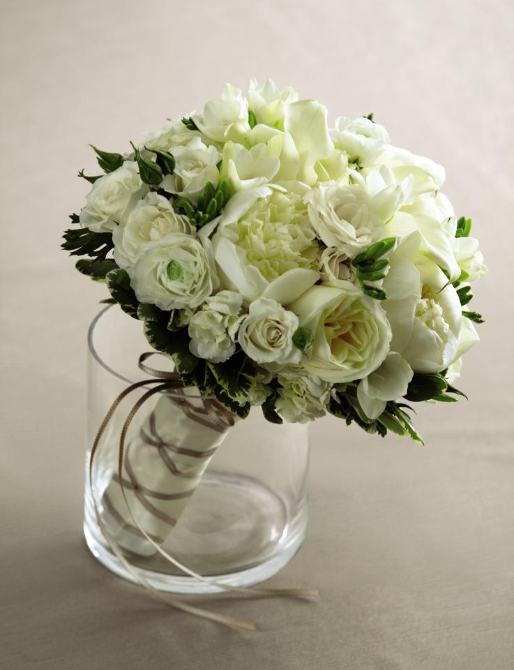 Garrden rose,ranunculus, freesia, peonies   Bouquet - This beautiful bouquet has a dream-like appeal that will be the perfect accessory on your wedding day. Gorgeous white ranunculus, roses, freesia, mini calla lilies, peonies, spray roses and hydrangea are brought together in this exquisite arrangement with lush greens and tied together with an ivory satin ribbon accented with a gold and ivory double sided stitch-edged satin ribbon to create a bouquet that speaks of the romance and heartfelt commitment made on this most remarkable day. Approx. 12-inches in diameter.