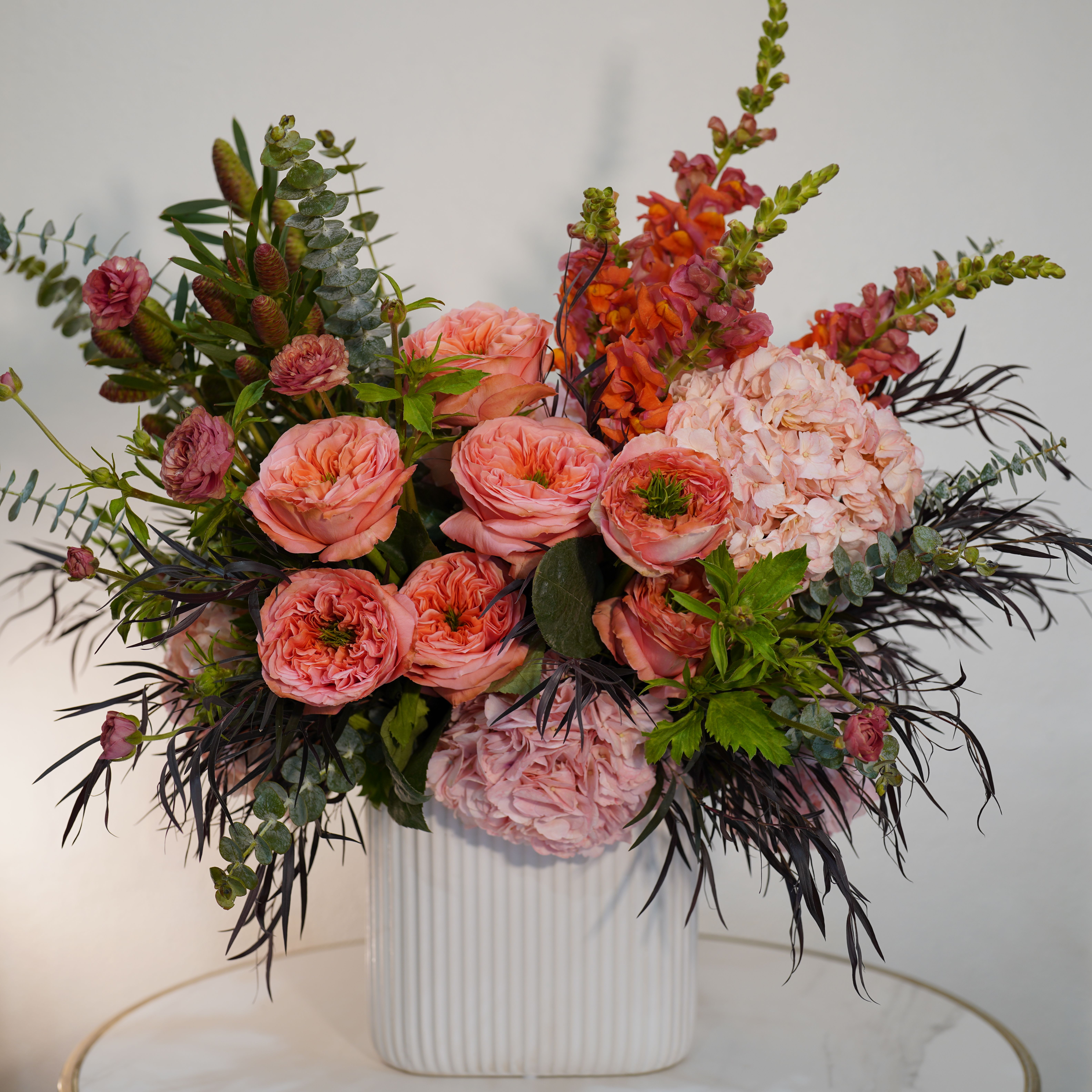  Blush Garden Luxe – Designer Floral Arrangement - Introducing the Blush Garden Luxe, a refined designer floral arrangement that blends soft elegance with artistic expression. This luxurious composition features a curated mix of premium seasonal blooms in delicate blush, peach, and soft pink tones, complemented by rich textures and natural greenery. Designed in a modern white ceramic vessel, this arrangement offers a perfect balance between structure and organic movement, creating a sophisticated and eye-catching centerpiece. Ideal for upscale interiors, special occasions, or meaningful gifts, this arrangement reflects a modern floral design style with a high-end aesthetic. Each piece is handcrafted by Guy Floral Studio, ensuring a unique, fresh, and beautifully styled result every time. Same-day flower delivery available in Beverly Hills, West Hollywood, Santa Monica, Beverly Grove, Bel Air, Culver City, and surrounding Los Angeles areas. The arrangement shown in the photo reflects our Deluxe size, featuring a fuller, more abundant design with premium blooms.
