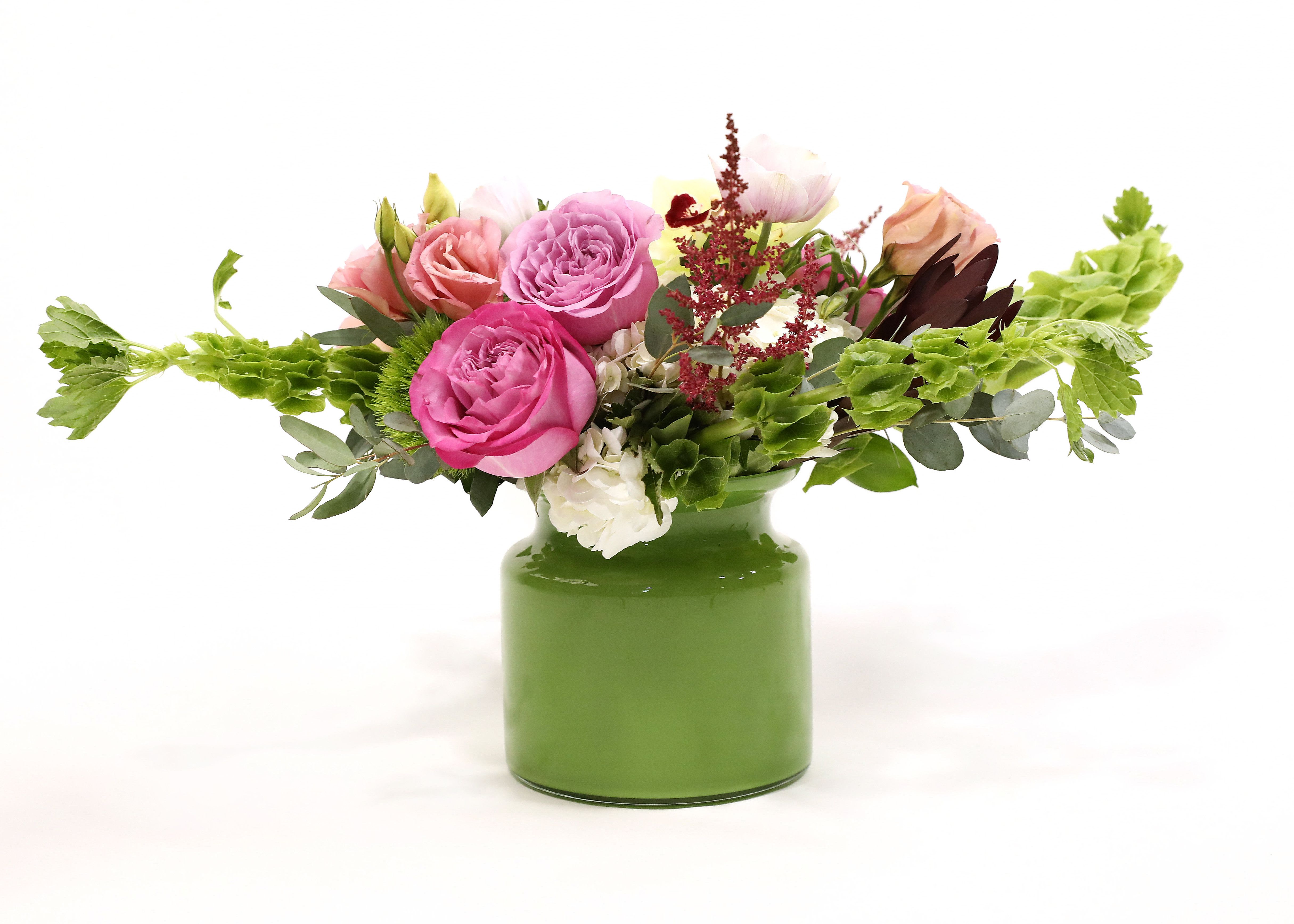 Pucker Up  - This bright, colorful short and compact arrangement will have your loved one pursing their lips. With wide variety of blooms Pucker Up contains: roses, agapanthus, hydrangea, cymbidium orchids, dianthus, hypericum, dusty miller, and bells of Ireland.