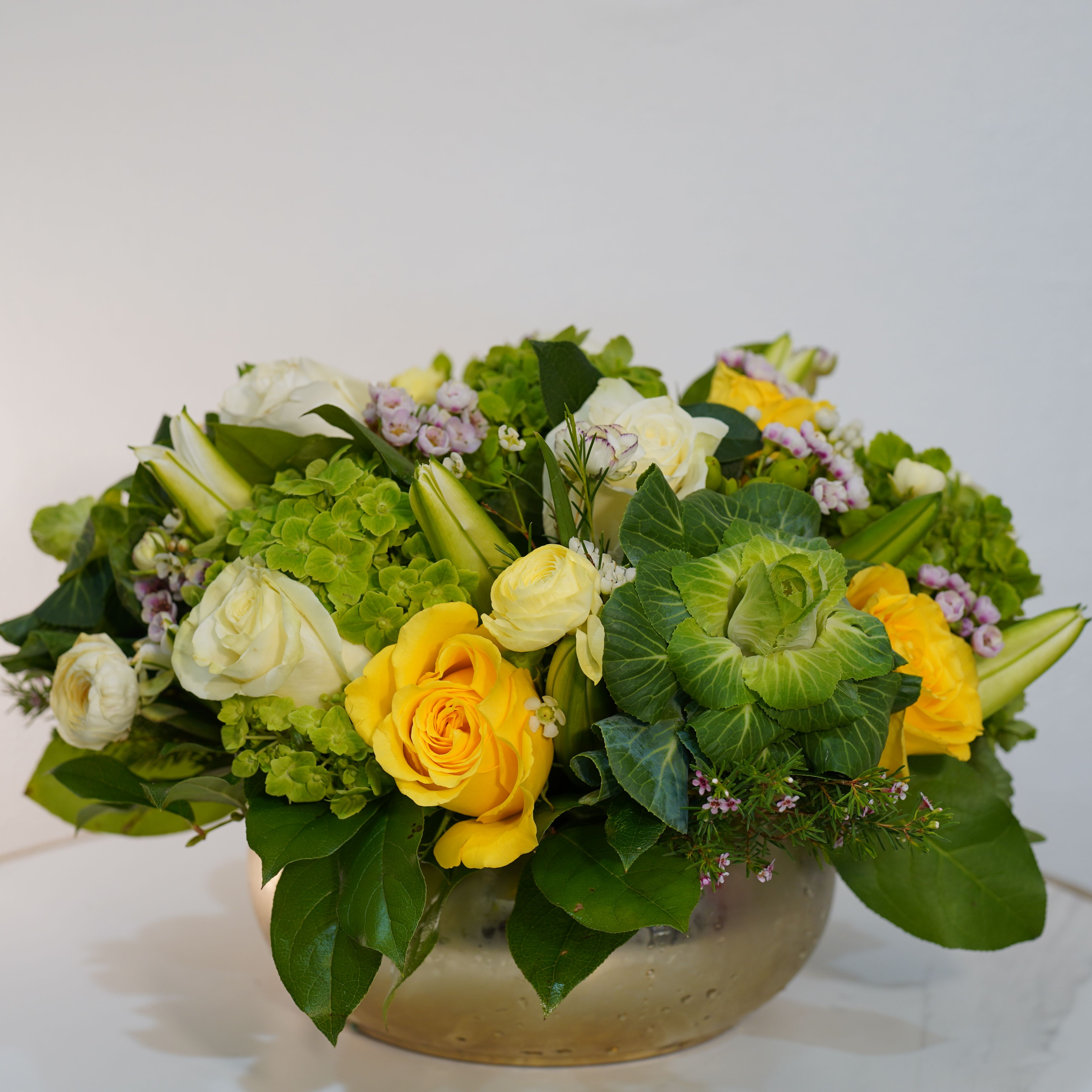 Sunny Garden  - Bright, fresh, and full of life — our Sunny Garden  arrangement is designed to bring warmth and happiness into any space. This beautiful composition features vibrant yellow blooms combined with rich green textures and fresh seasonal flowers, all styled in a modern low-profile planter. The mix of colors and natural elements creates a lively yet elegant design that instantly uplifts any room. Perfect for birthdays, celebrations, thank-you gifts, or simply to brighten someone’s day, this arrangement delivers a joyful and sophisticated touch. Each piece is handcrafted by Guy Floral Studio using premium fresh flowers, ensuring a unique and high-end presentation every time. Same-day flower delivery available in Beverly Hills, West Hollywood, Santa Monica, Beverly Grove, Bel Air, Culver City, and surrounding Los Angeles areas. The arrangement shown in the photo reflects our Deluxe size, featuring a fuller, more abundant design with premium blooms.