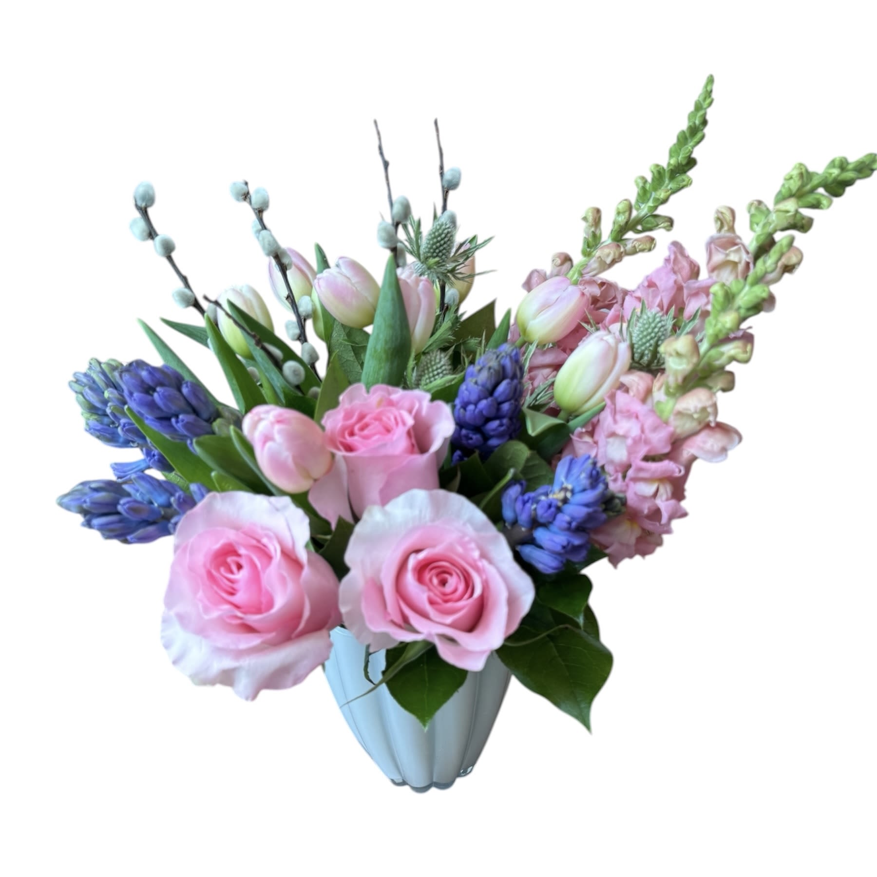 Morning Blossom - Pink roses, pink snapdragons, purple hyacinths, blue thistle, pink tulip and pussy willow designed in a white glass vase. As shown in photo.