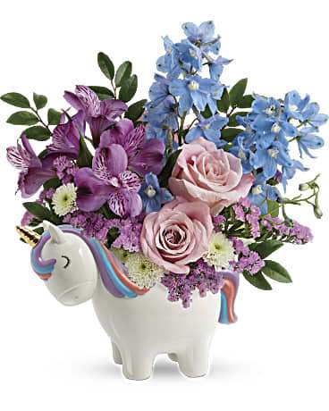 Teleflora's Enchanting Pastels Unicorn Bouquet - Pure enchantment! This sweet ceramic unicorn with hand-painted details can't wait to share this pretty pastel bouquet with your someone special! This enchanting arrangement features light pink roses, purple alstroemeria, light blue delphinium, white button spray chrysanthemums and pink statice.  One sided 12.5” Tall 11.5” Wide