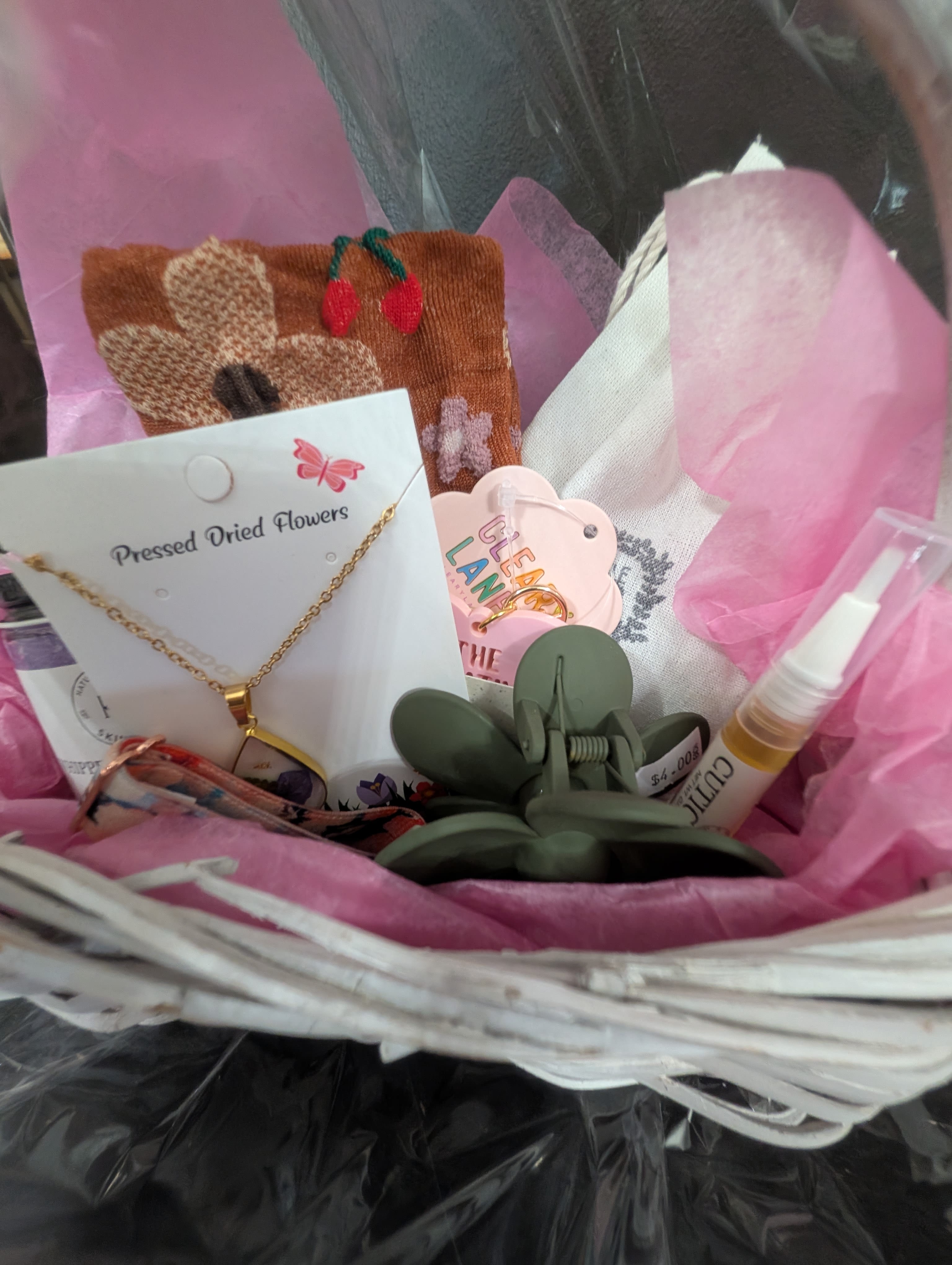 Mini Gift Basket  - A mini gift basket with a hair clip, socks, cuticle oil, a pressed flower necklace, body scrub, a chapstick and a mini candle.
