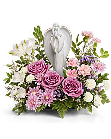 Ever So Loved - Express gentle comfort and timeless grace with Ever So Loved Bouquet, a serene blend of lavender roses, soft pink blooms, and delicate white flowers surrounding a porcelain angel keepsake. Ever So Loved Bouquet includes lavender roses, light-pink alstroemeria, pink mini carnations, white button spray chrysanthemums, lavender cushion mums, lavender statice, and limonium. Accented with huckleberry and leatherleaf fern. Presented with an Angel of Grace keepsake. Approximately 16" W x 12 1/2" H
