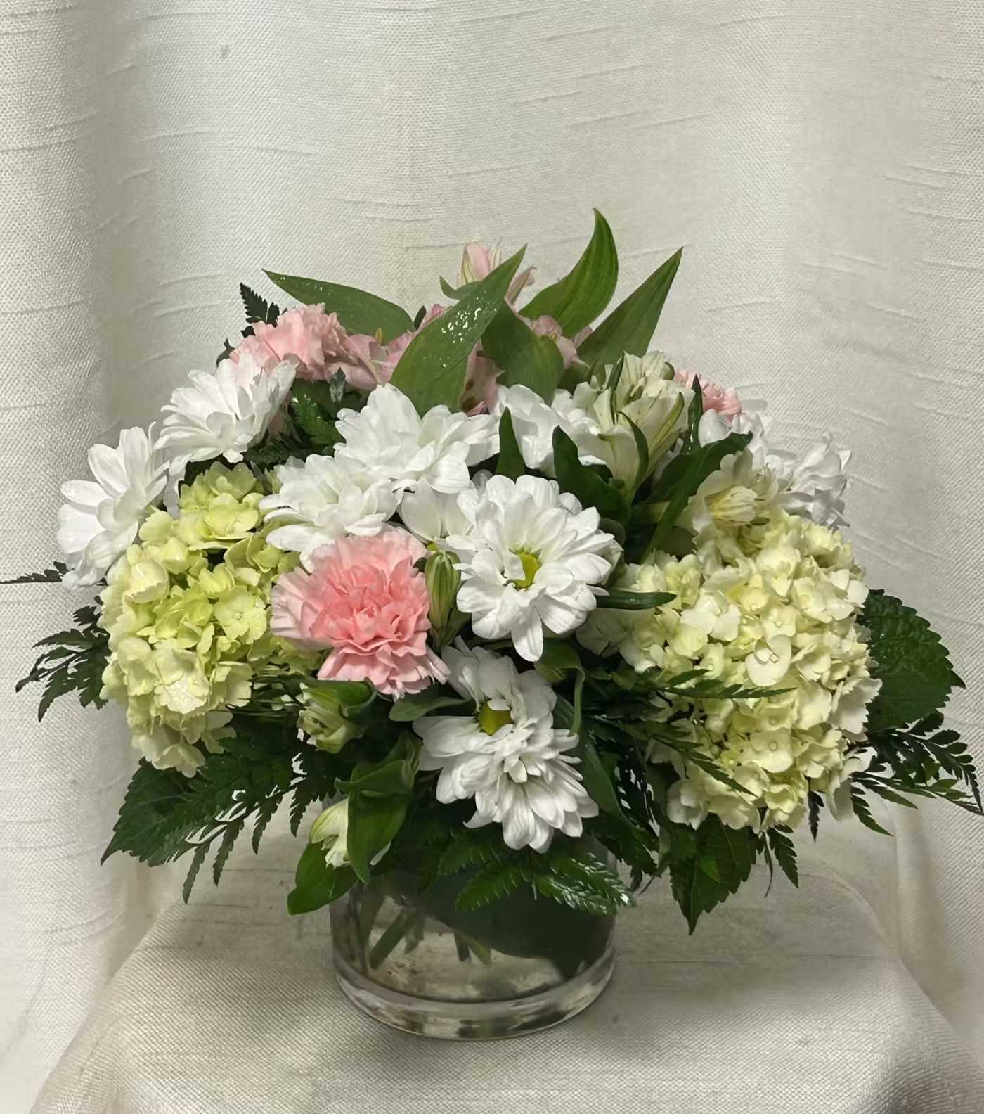 Pastel Horizons (DL) - Sometimes simple is better! Soft toned florals arranged in a modern style clear glass cylinder vase by our experienced designers.  An array of soft colored flowers including, Alstroemeria, hydrangea daisies, &amp; more. Perfect for any occasion in the home or office