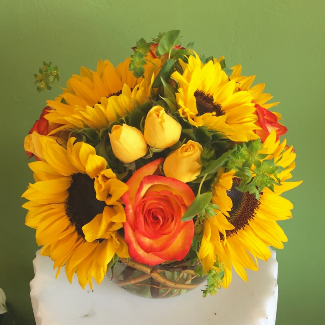Suns glow - Combination of yellow sun flowers and orange roses in a clear glaas bubble bow is a warm gift sending to your loved ones!