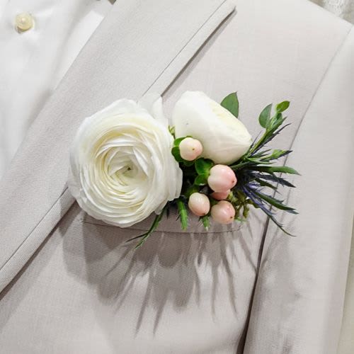 White Pocket Square Boutonniere  - Pocket Square Boutonniere with White Ranunculus &amp; Pink Hypericum  Looking for a modern twist on the classic boutonniere? Our Pocket Square Boutonniere is a stylish and sophisticated choice that slips right into the front pocket of a suit or tux. No pins required! Designed with elegant white ranunculus and soft pink hypericum berries, this arrangement adds a fresh, contemporary flair to any formal outfit.  Perfect for weddings, proms, or special events, this sleek floral accent is easy to wear and makes a lasting impression.  Want to match your color palette? We can customize this boutonniere with any color flowers to coordinate with your event. Just give us a call at 360-688-6608 or leave your preferences in the "Special Instructions" box at checkout.  Handcrafted with care by the designers at Specialty Floral Design in Olympia, WA—where every detail matters.  