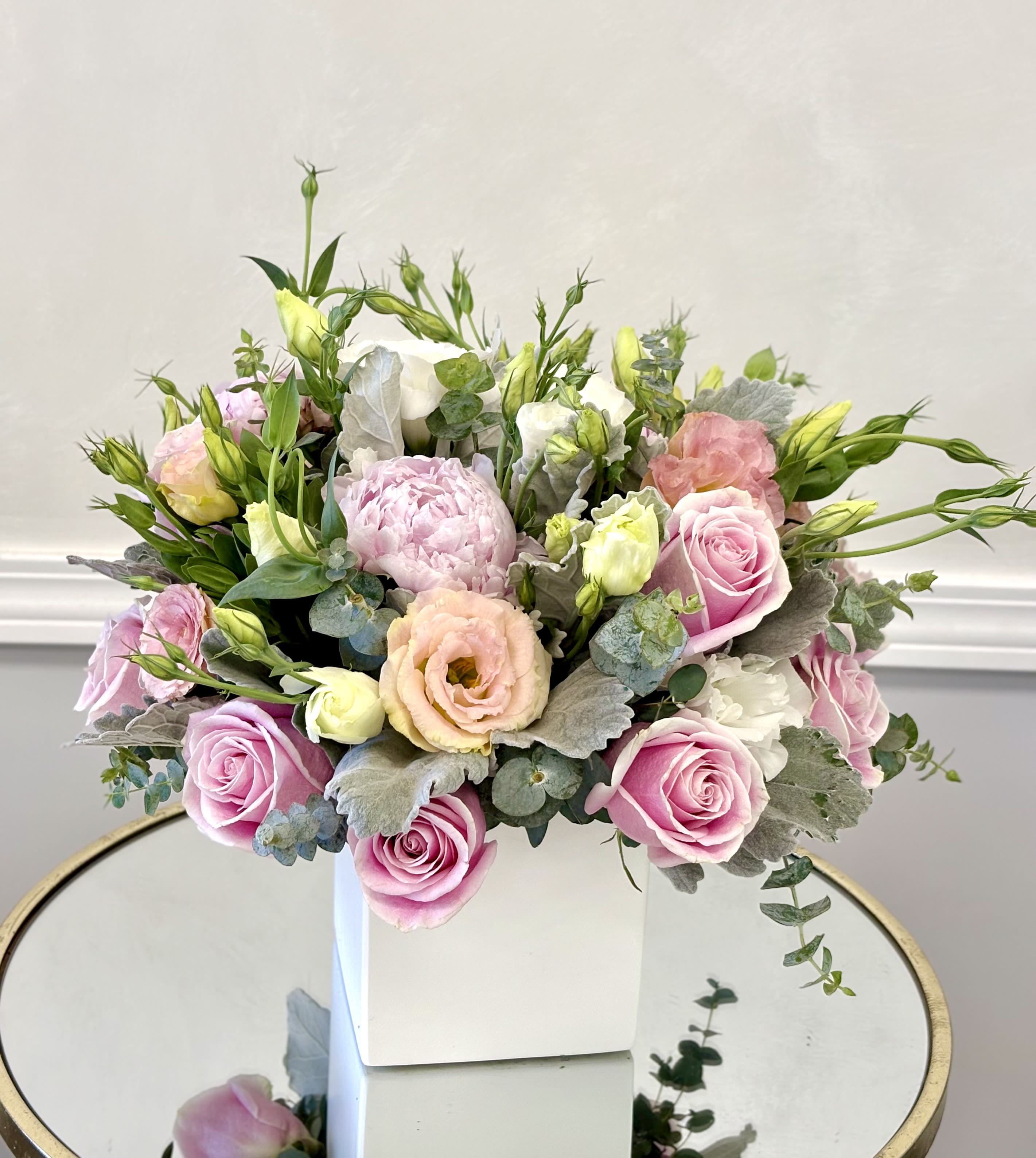 Blush Garden Bloom By VLM Flowers - A beautifully curated arrangement of soft pink and creamy blooms, Blush Garden Bloom captures the effortless charm of a fresh garden in full bloom. Featuring delicate roses, lush peonies, and airy lisianthus, this design is complemented by touches of fresh greenery and eucalyptus for a natural, organic feel. Its light, romantic palette and loose, flowing style create a sense of elegance and tranquility, making it perfect for celebrations, thoughtful gifts, or adding a refined touch to any space.