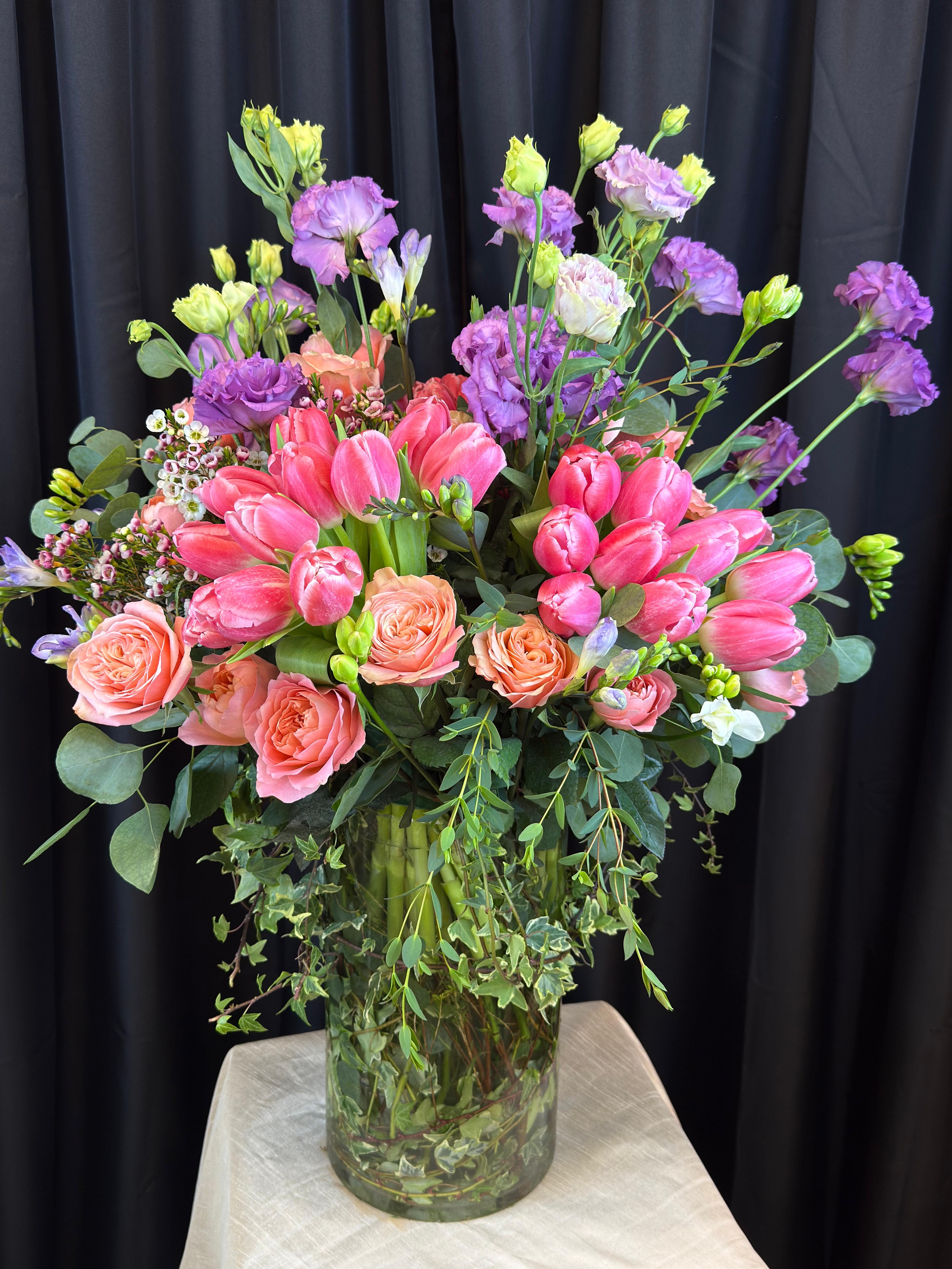 Jardin de Couleur - Jardin de Couleur is a vibrant, luxurious arrangement that celebrates the joy of color in full bloom. Lush tulips, fragrant freesia, and elegant lisianthus are artfully arranged in a kaleidoscope of bright, cheerful hues.