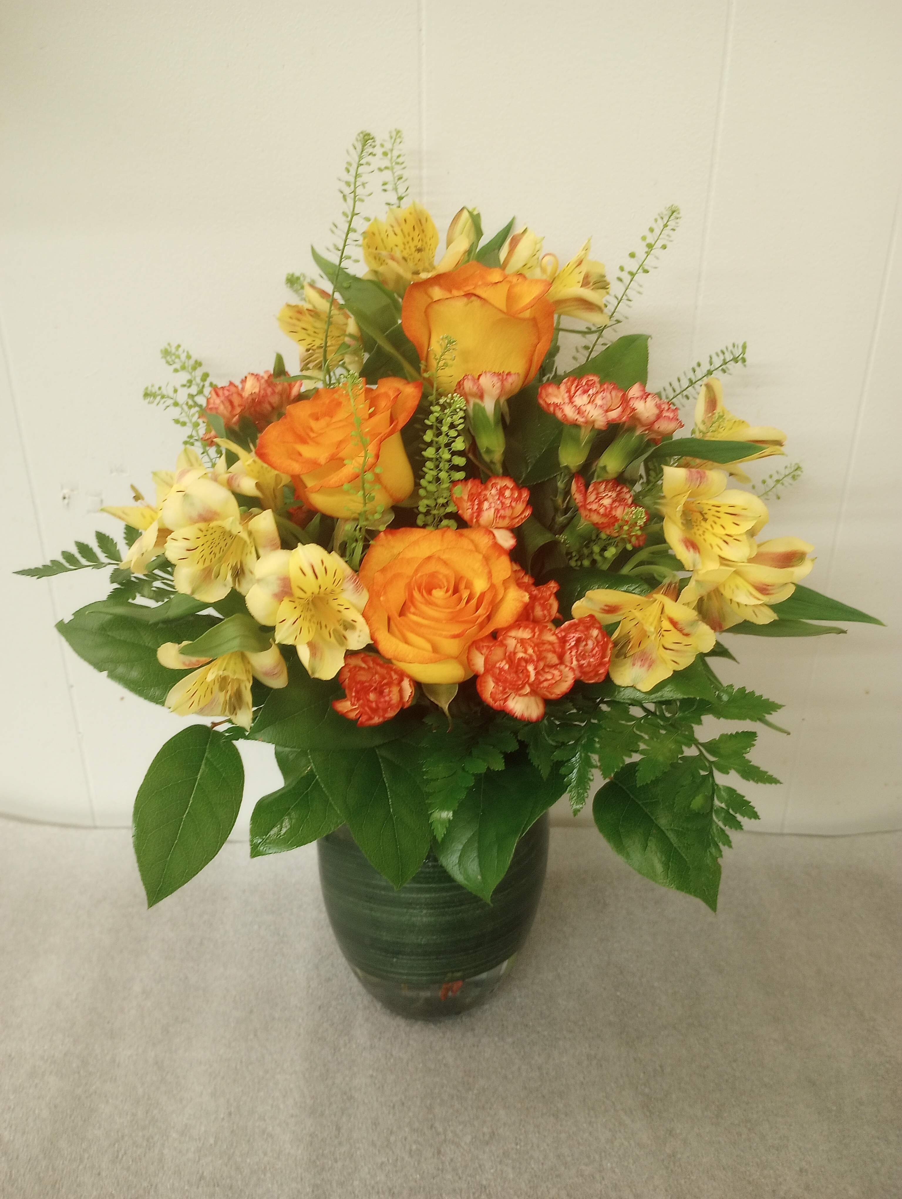 My Sunshine  - Bi color red/yellow roses, yellow alstroemeria and orange mini carnations arranged in a  clear vase with a ti leaf looking ribbon.