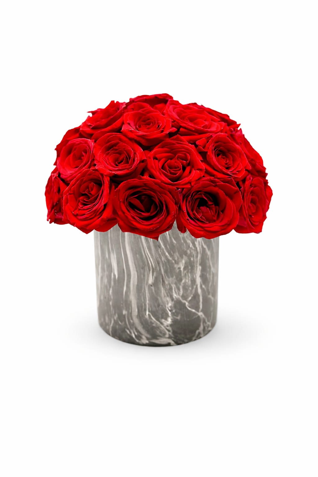 Compact arrangement of red roses in a gray marble-patterned cylinder vase