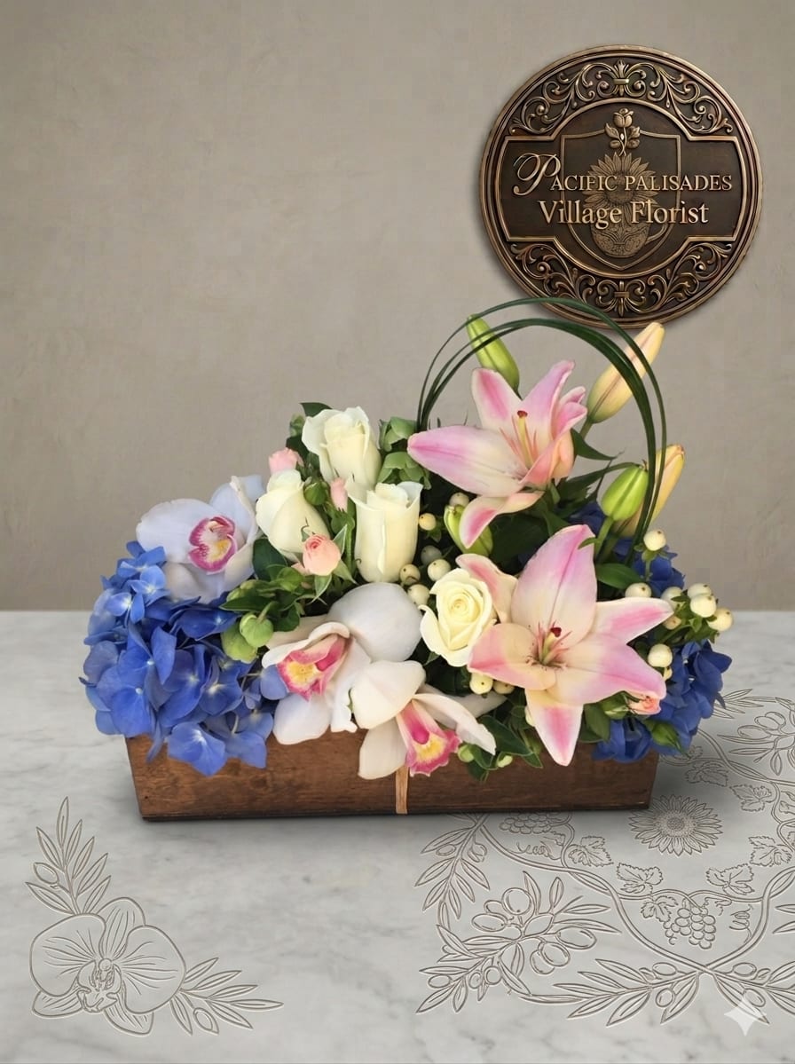 Easter Sunday - A soft, elegant arrangement blending romantic pink lilies with creamy white roses and delicate orchids, accented by clusters of blue hydrangea and subtle white berries. The design feels airy and graceful, with gentle color transitions and a natural, garden-inspired composition set in a rustic wooden container.