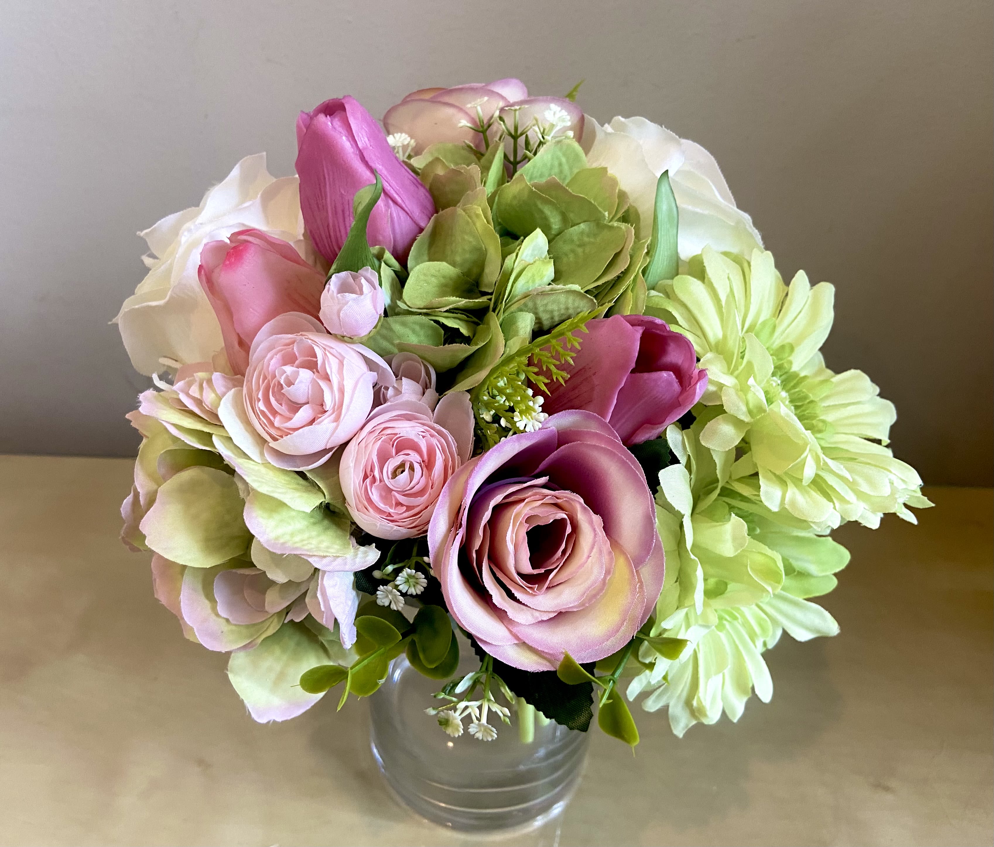 Lovely - Silk Floral Bouquet - Handtied silk floral bouquet in glass vase.  Lovely combination of tulips, roses, ranunculus, hydrangea and gerbera daisies in mauves, lavender, pink, white &amp; green.