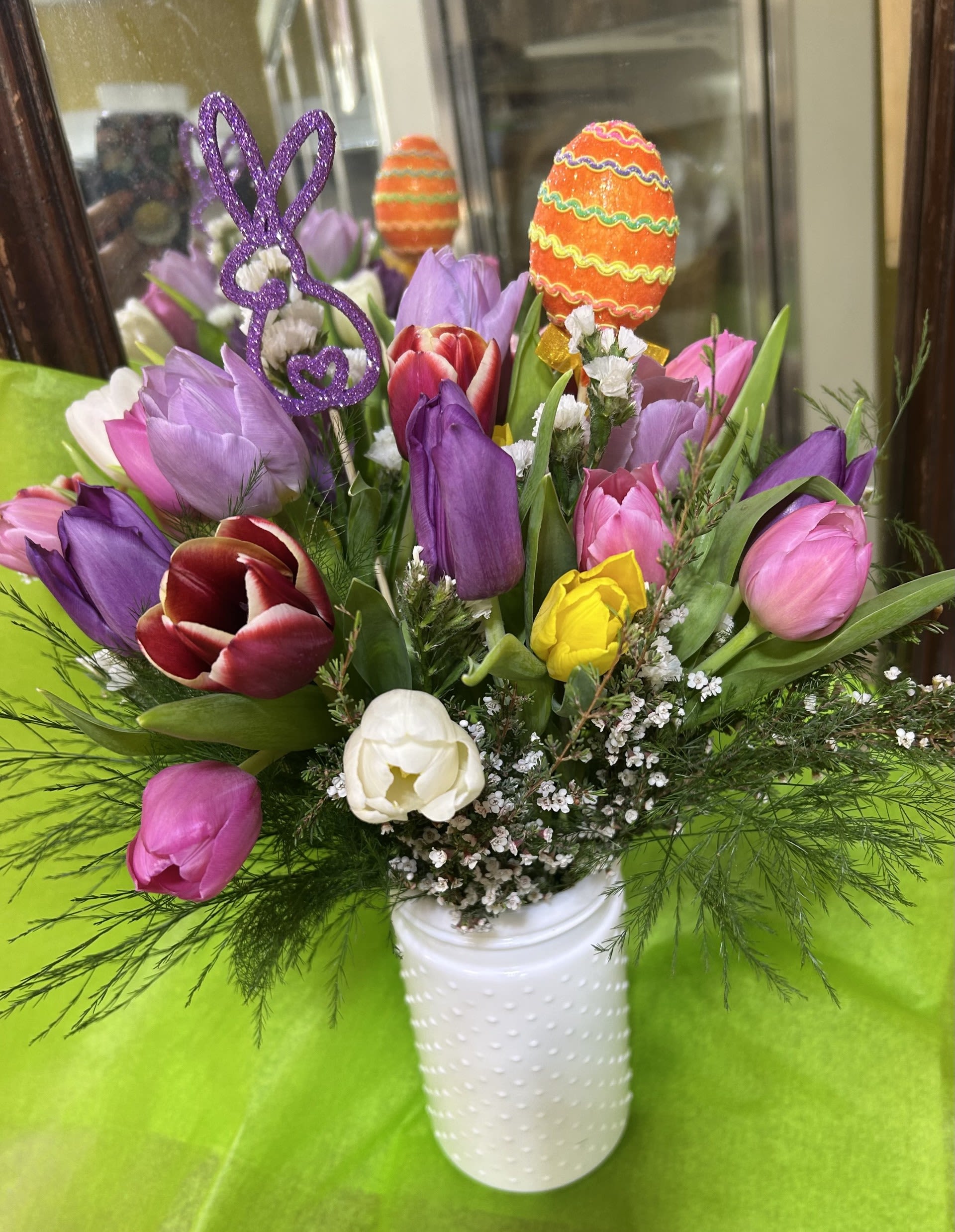 Hoppy Easter Tulips 75/100/125 - 2 dozen mixed tulips in a white hobnail vase with statice and pink Heather.  