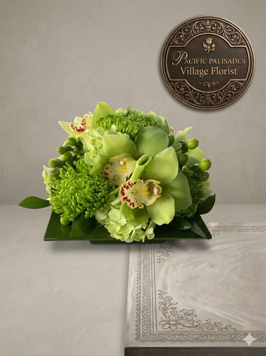 Irish Spring - A fresh, monochromatic green arrangement featuring elegant cymbidium orchids surrounded by textured green chrysanthemums and soft hydrangea, accented with glossy foliage and berries. The design feels modern and serene, with rich layers of green tones creating a clean, sculptural look.