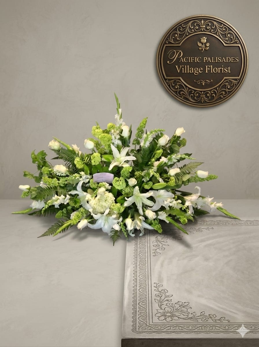 Missing You - A serene, elongated sympathy-style arrangement in soft whites and fresh greens, featuring elegant lilies and roses layered with textured blooms and lush fern accents. The design feels peaceful and refined, with a natural, flowing shape that conveys grace and remembrance.
