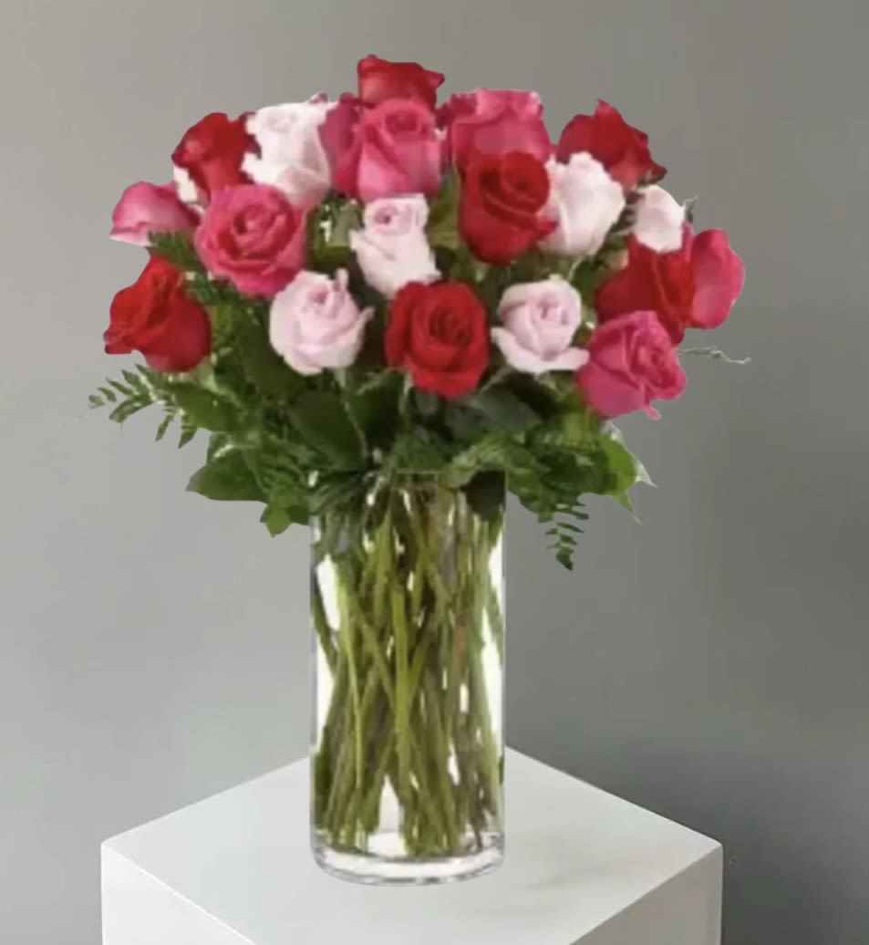 Bouquet of red, pink, and white roses in a clear glass vase