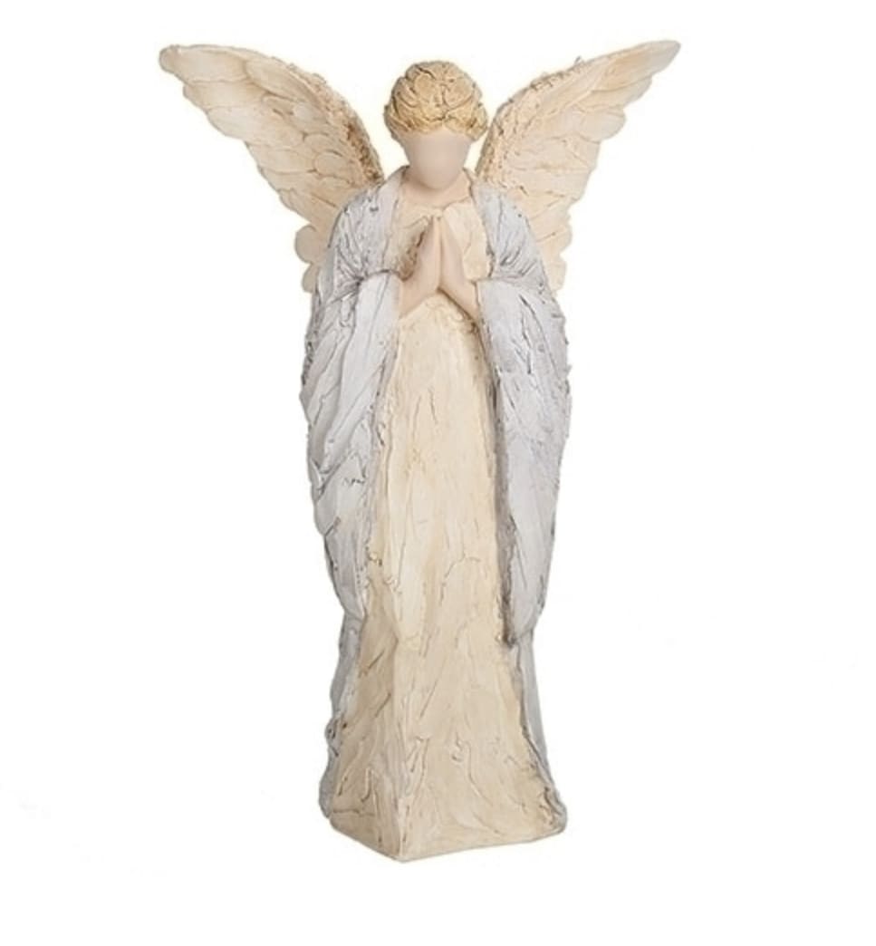 Cream-colored angel figurine with folded hands and large wings