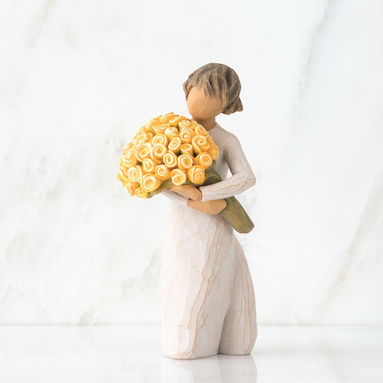Kneeling figurine holding a large yellow rose bouquet against a light background
