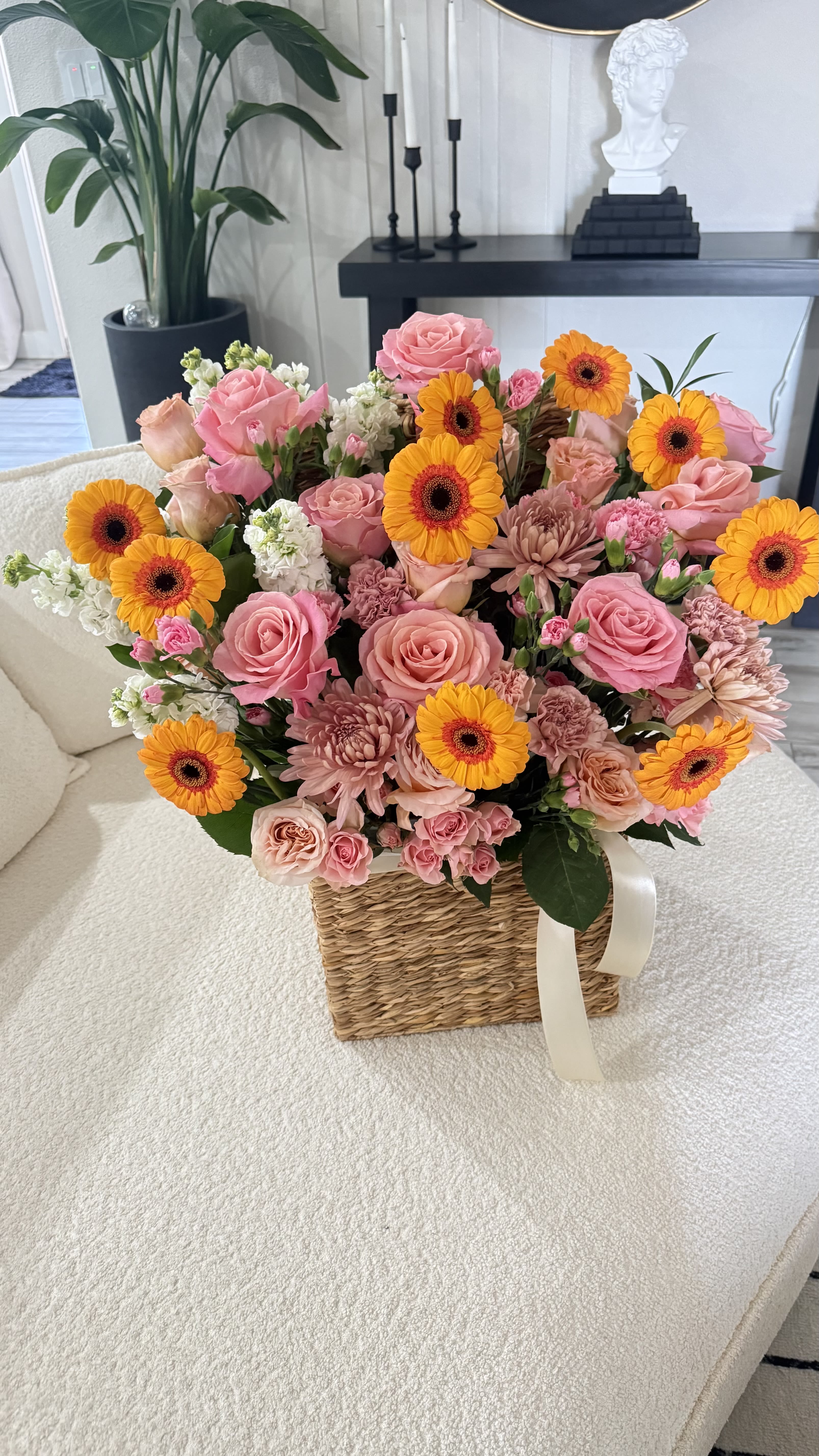 Sunset Garden Basket - Bright, joyful, and full of life — our Sunset Garden Basket is designed to make anyone smile instantly.  This stunning arrangement features a beautiful mix of premium roses, vibrant gerbera daisies, soft chrysanthemums, and delicate filler flowers, all carefully arranged in a charming woven basket with elegant ribbon detail.  The warm tones of pink, peach, and golden yellow create a fresh and uplifting look, perfect for birthdays, celebrations, or simply to brighten someone’s day.   Handcrafted with care by Lone Star Gifts  Available for delivery in Midland, Odessa &amp; Gardendale  Same-day delivery available (order early) 