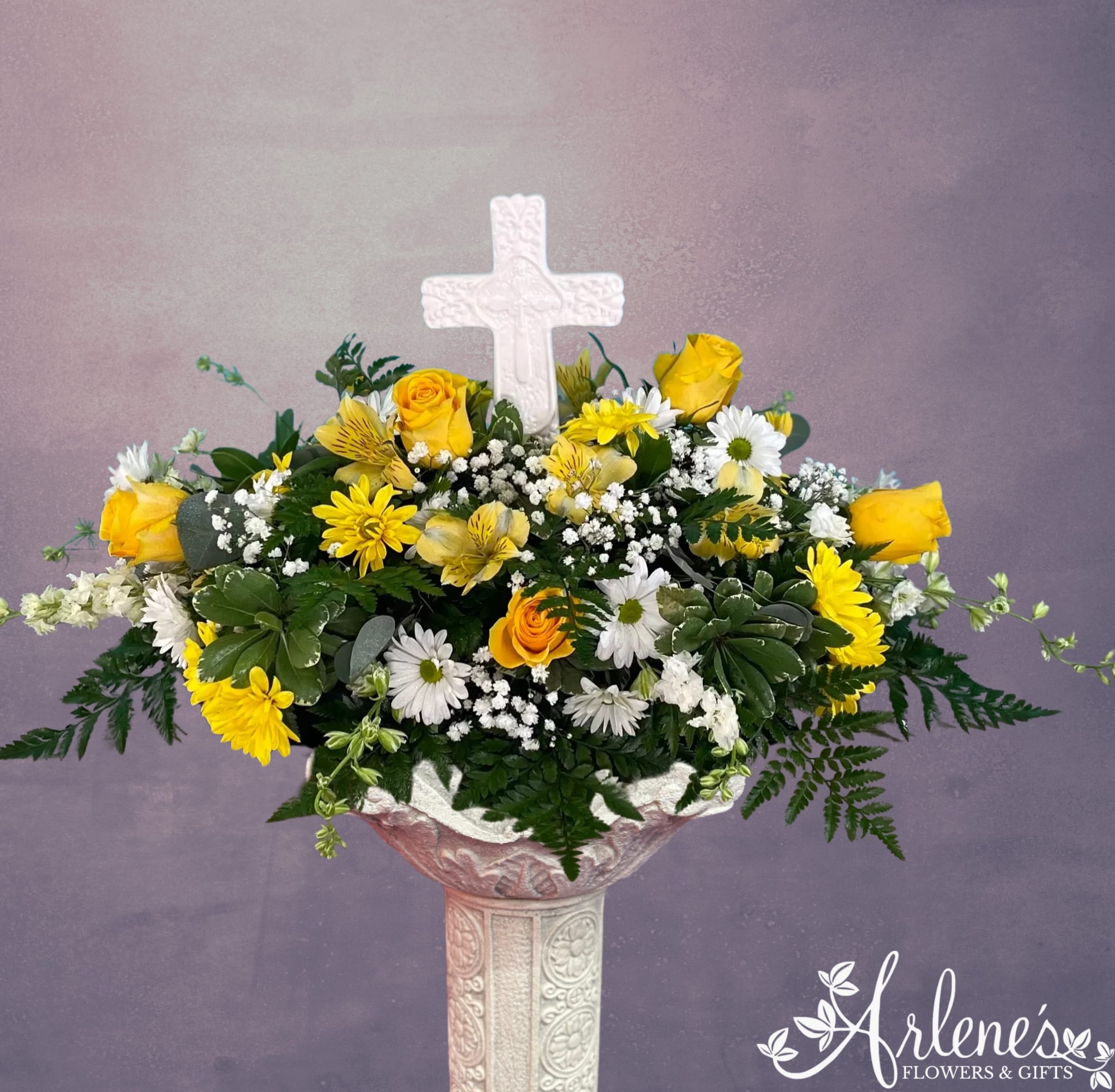 Daisy, Rose and Cross -  A ceramic cross rises from a field of roses and daisies. This is a small arrangement, approximately 8 inches tall and 12 in wide.