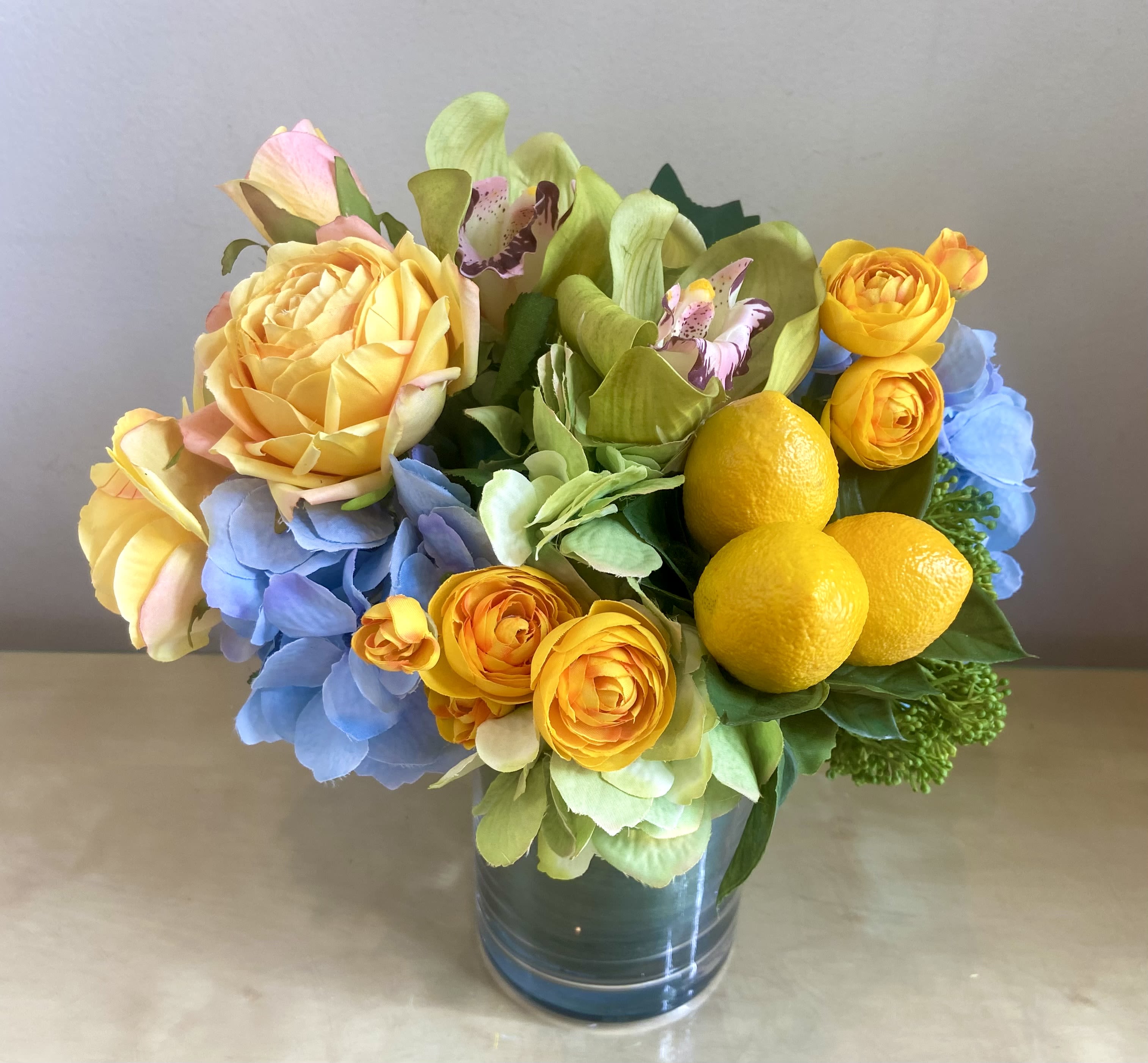 Sunny Spring - Silk Floral Arrangement - Sunny Silk floral arrangement in yellow, blue and lime green. Hydrangea, roses, ranunculus, cymbdium orchid blossoms and a cluster of lemons!  Great table centerpiece.