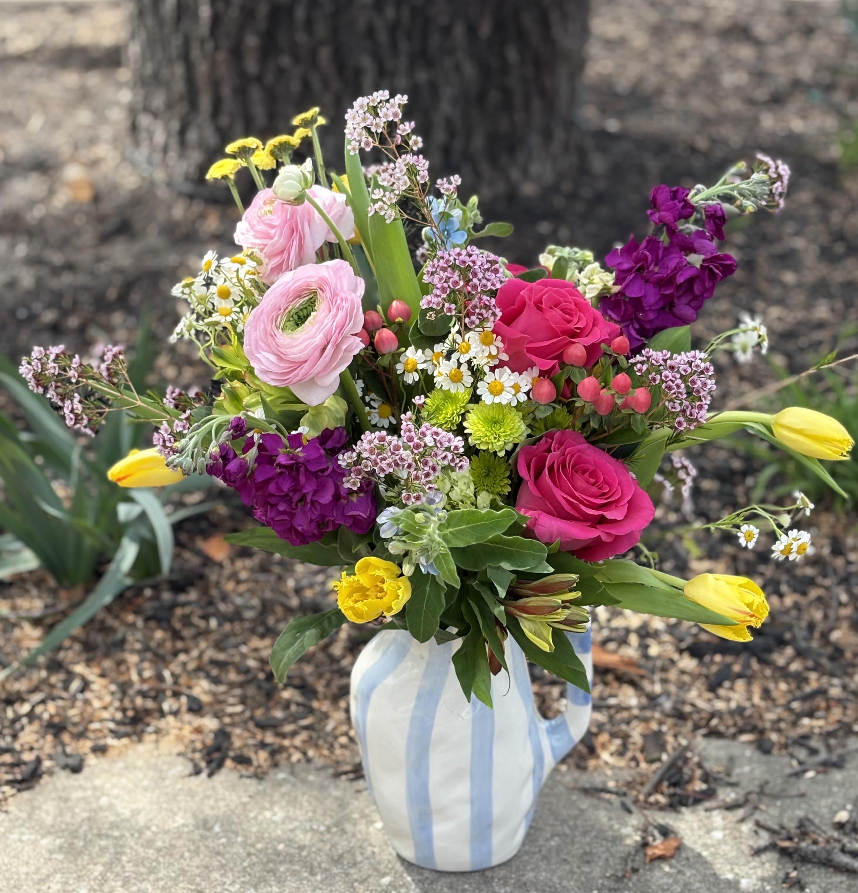 Whimsical Pitcher - Whimsical ceramic pitcher overflowing with a bright and beautiful assortment of fresh seasonal flowers! Vibrant colors and fragrant blooms make this arrangement a winner with flower lovers! Ceramic keepsake pitcher measures approximately 8" tall. Arrangement approximately 17"H x 17"W.