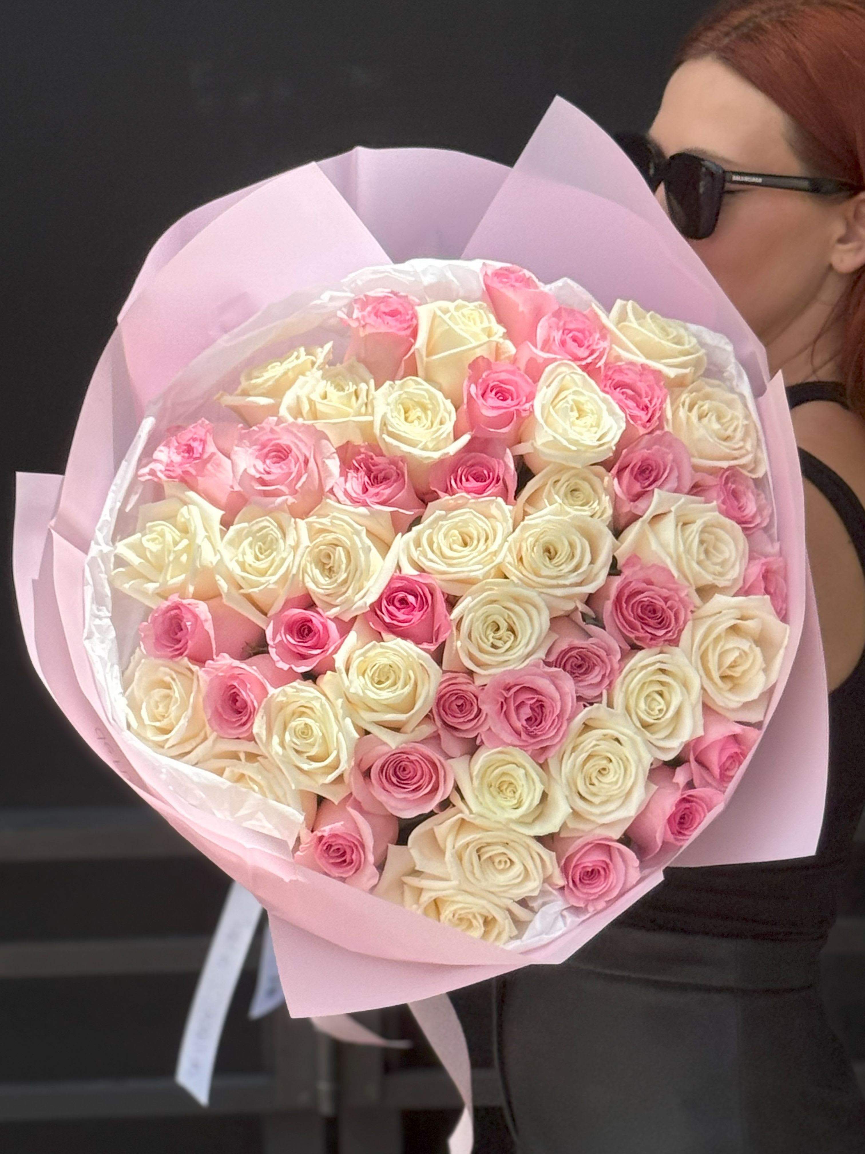 50 Pink and White Roses Mixed Premium Bouquet - Command attention with our Rose Empress — a grand, opulent bouquet featuring over 50 premium roses in a regal blend of creamy ivory, soft blush, and romantic pink tones. Wrapped in luxe pastel paper and tied with signature satin ribbon, this show-stopping arrangement radiates elegance and grace.  Perfect for milestone celebrations, luxury gifting, or unforgettable romantic gestures, the Rose Empress is designed to captivate at first sight.   Includes a greeting card, flower food, aqua box or vase, and free delivery  Available in limited quantities for those who love floral drama in the most elegant way  Give a gift that reigns with beauty.  Standard - 48-50 roses Deluxe - 73-75 roses Premium - 98-100 roses 