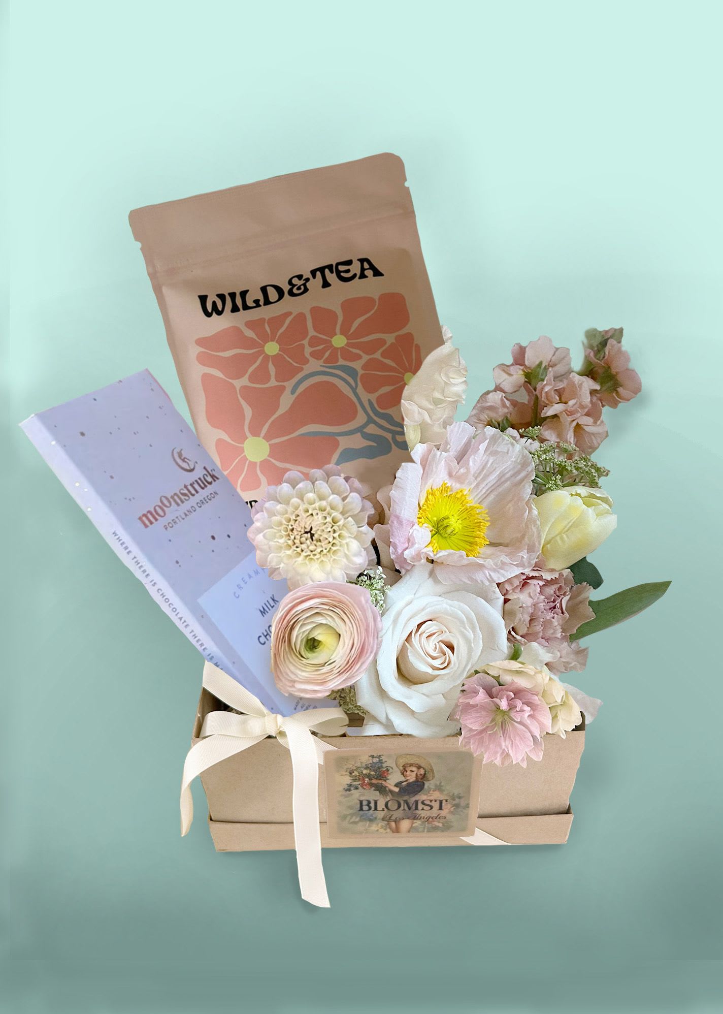 Betty Blush Box - The lovely small box of tea, chocolate and flowers is bound to please any recipient. The pastel blush colors fit almost all occasions. The pretty box contains: Bergamot Blossoms Tea. Organic Ingredients: Red rooibos, chamomile, orange peel, rosehips, cornflower, rose and bergamot oil. Moonstruck Creamy Milk Chocolate Bar and a gorgeous mini Blomst arrangement. Placed in a reusable papermache gift box with lid. Ready for hand delivery in LA.   