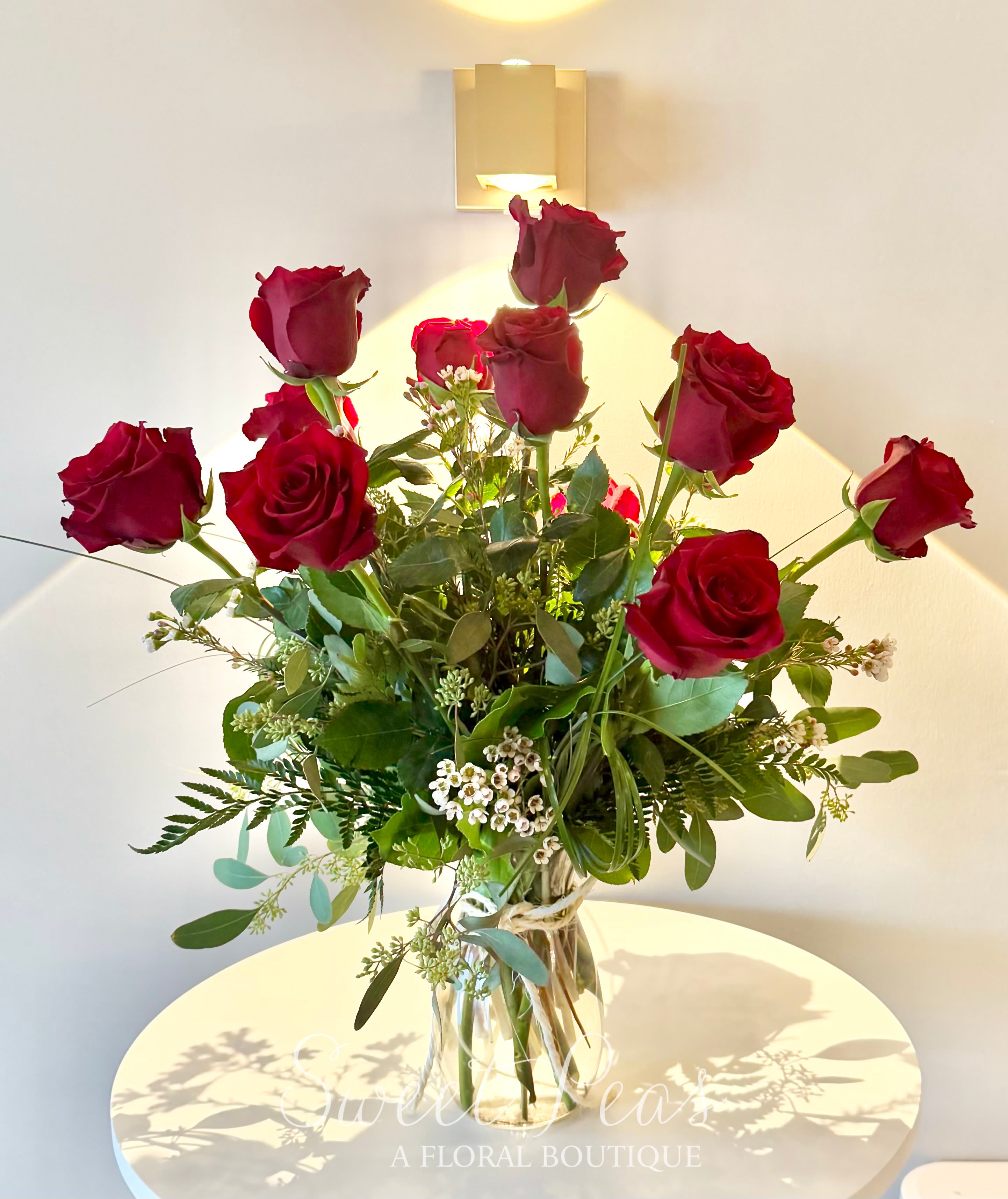 Tall bouquet of red roses in a clear glass vase