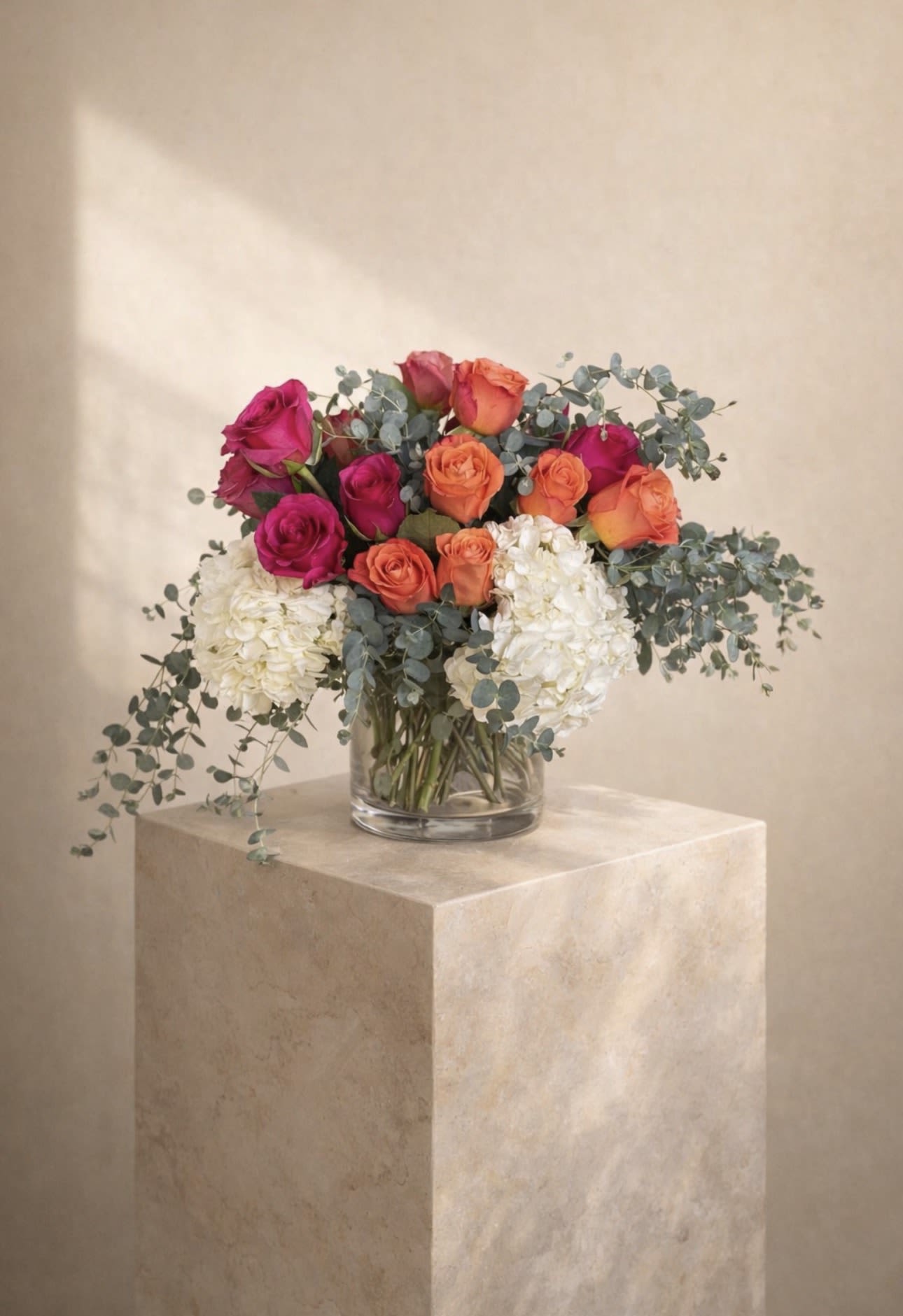Fresh calm - Bright &amp; Elegant Arrangement A vibrant mix of roses and hydrangeas with soft eucalyptus accents in a clear glass vase.