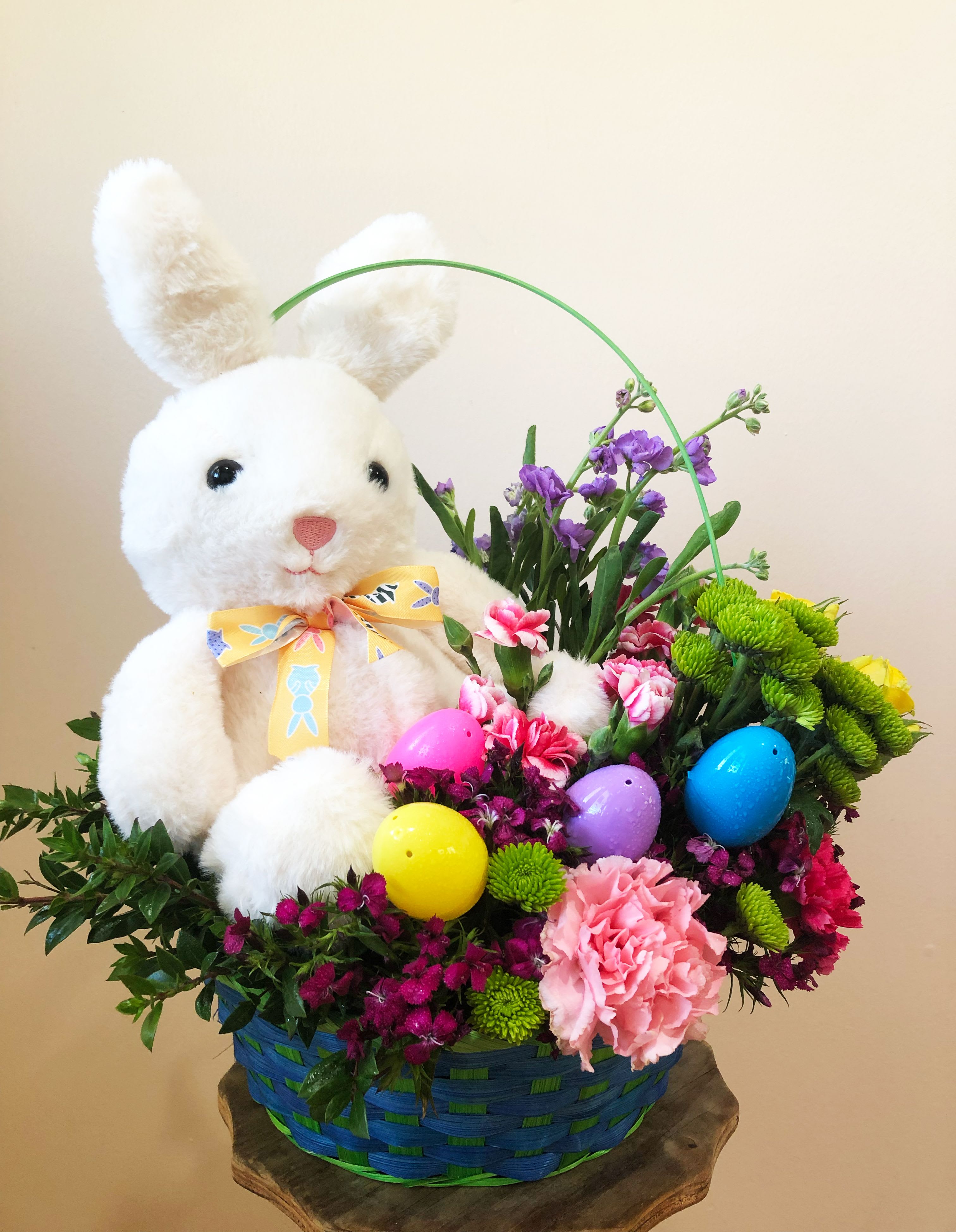 Easter Bunny Blossom Basket - Celebrate the joy of Easter with our charming Easter Bunny Blossom Basket! This delightful arrangement features a cuddly plush bunny nestled among a vibrant mix of fresh spring blooms, including carnations, daisies, and lush greenery. Accented with colorful Easter eggs, this festive basket brings a touch of seasonal cheer to any home or special gathering. Perfect as a centerpiece or a heartfelt gift, this arrangement captures the spirit of Easter in the most beautiful way.