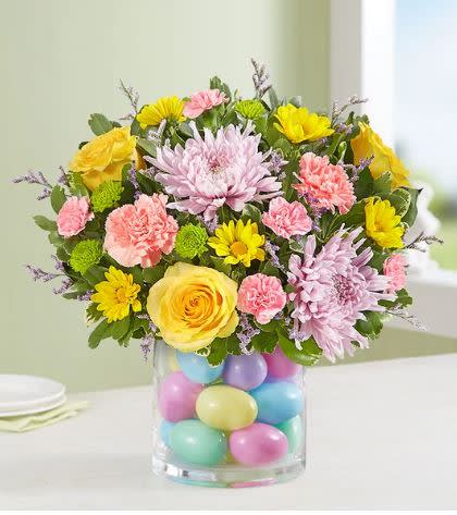 Easter Egg-Stravaganza - Our pastel bouquet brings fresh-picked spring beauty—and plenty of fun—into every home at Easter. Softly-colored blooms are gathered in a clear glass cylinder vase filled with colorful plastic eggs for a uniquely playful touch. Surprising family &amp; friends or decorating your own table, this gift’s sure to make the holiday celebration even more special.