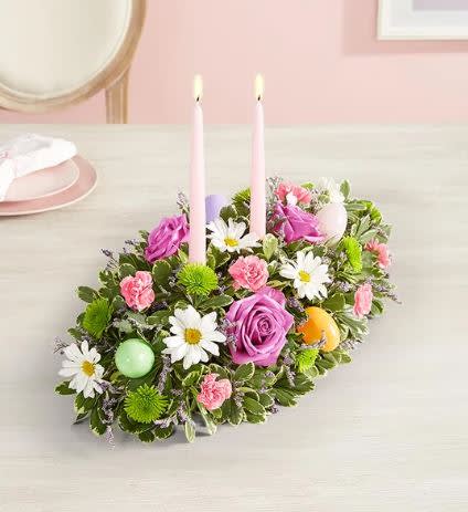 Easter Centerpiece - Easter celebrations call for beautiful flowers. Our classic centerpiece is filled with pastel blooms and accented by colorful plastic Easter eggs for a playful touch. Elegant taper candles finish off this charming arrangement, which is sure to be the bright spot of the holiday table.