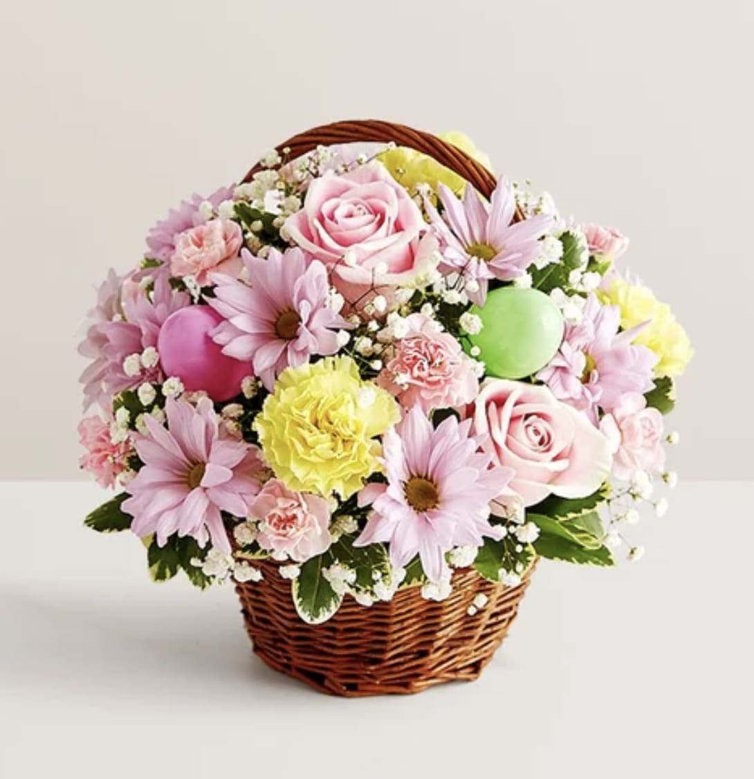 Easter Egg Basket - A delightful way to deliver Easter wishes. We’ve gathered fresh-picked pastel blooms and colorful eggs inside a charming handled basket. It’s a gift of instant happiness for family and friends, both near and far.