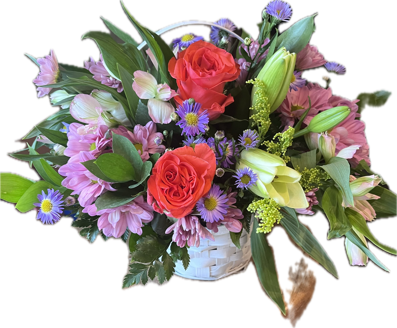 Coral Crush Garden Basket Arrangement - A charming garden-style basket featuring coral roses, soft pink blooms, lavender asters, and fresh greenery. Designed with a natural, airy feel, this arrangement captures the beauty of a blooming spring meadow—perfect for brightening someone’s day with color and elegance. 